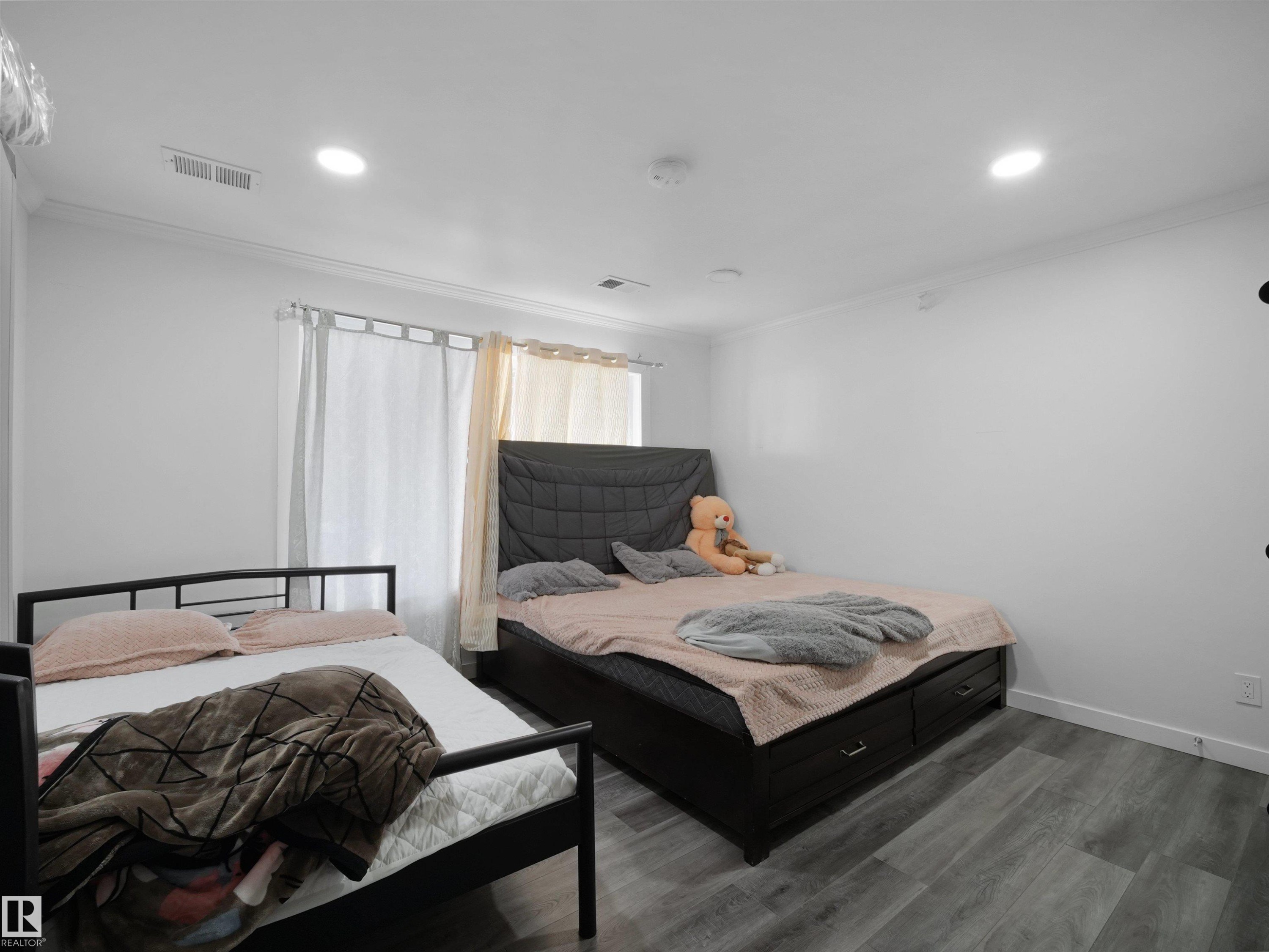 The room features recessed lighting, light-colored walls, and wood-look flooring - 4231 Charles Close, Edmonton, AB - Indoor Photo Showing Bedroom
