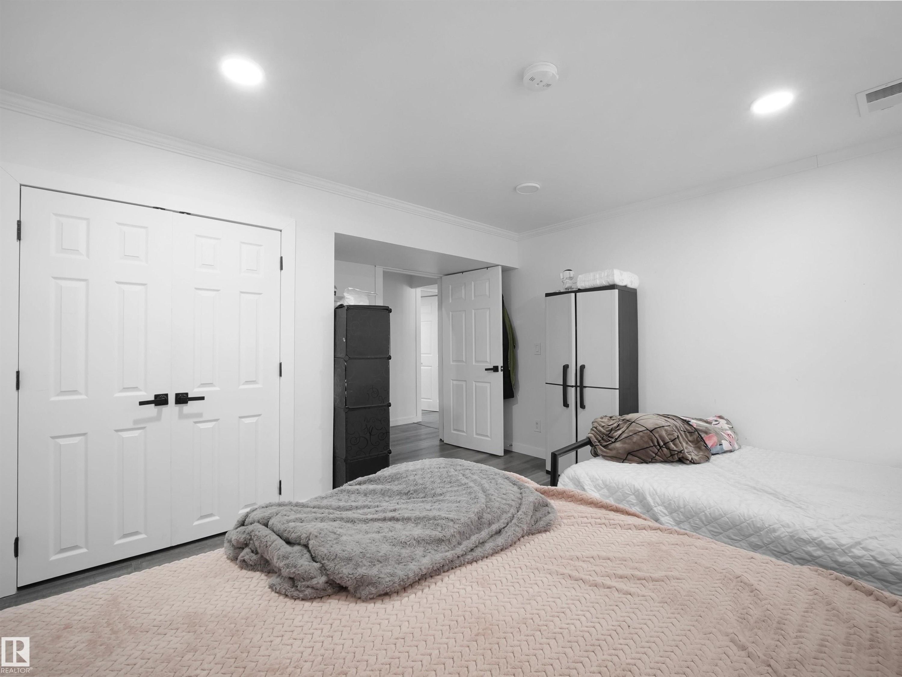 This room features white walls, recessed ceiling lighting, crown molding, and light-toned flooring - 4231 Charles Close, Edmonton, AB - Indoor Photo Showing Bedroom