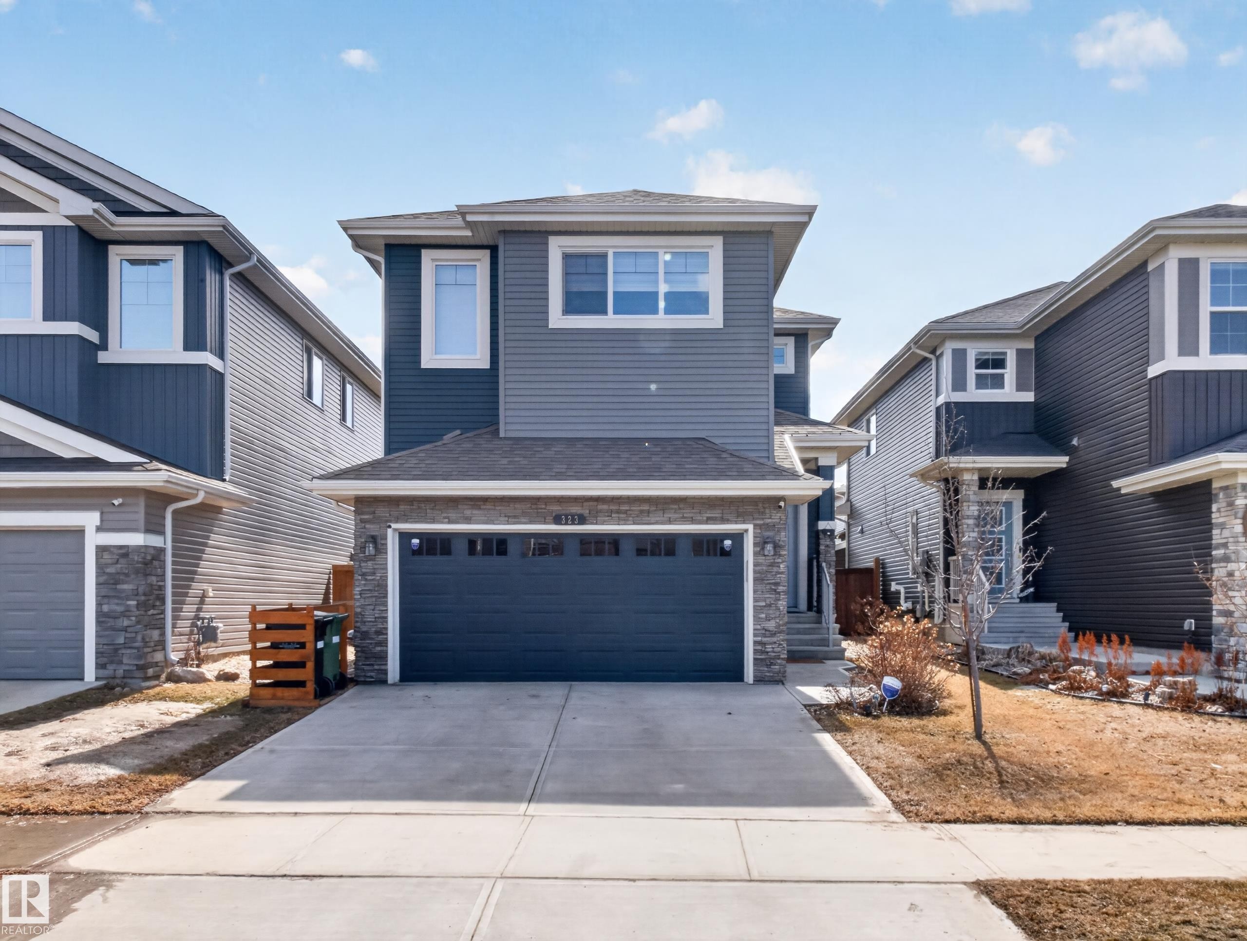 Modern two-story home featuring a combination siding and stone facade - 323 Balsam Link, Leduc, AB - Outdoor With Facade