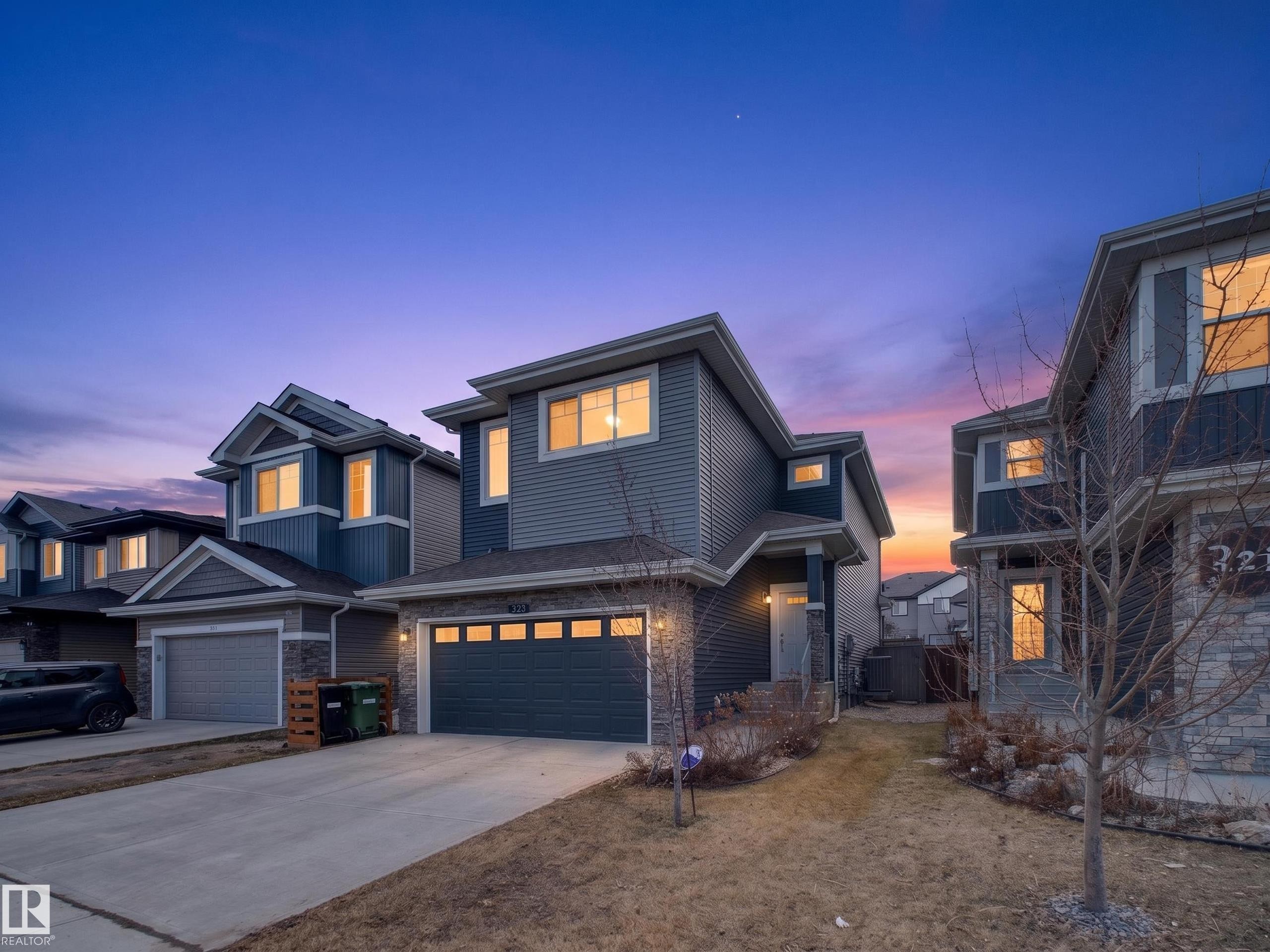 Contemporary two-story exterior with multi-toned siding and stone accents - 323 Balsam Link, Leduc, AB - Outdoor With Facade