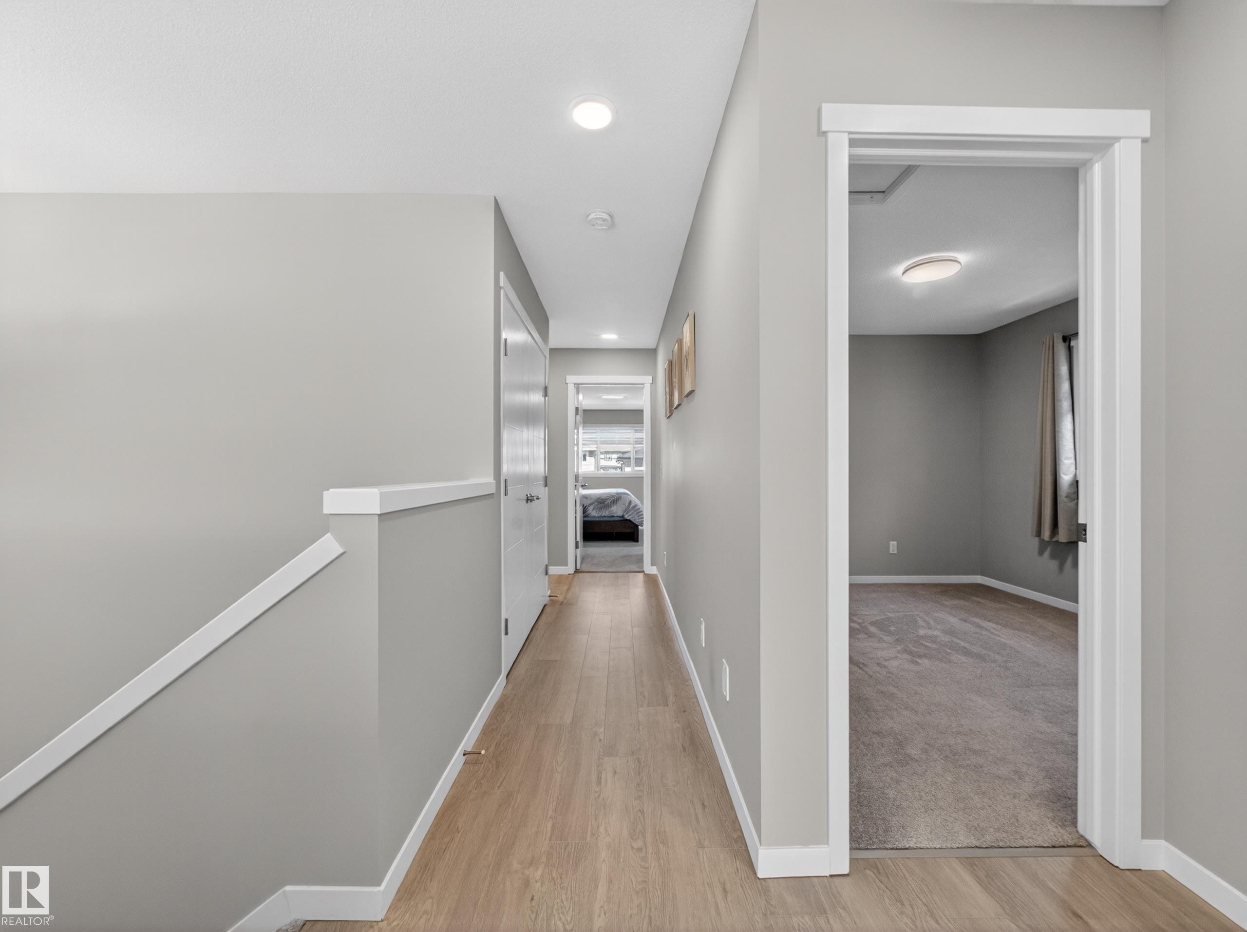 Hallway featuring light wood-finish flooring, neutral gray walls, white trim, and recessed lighting - 323 Balsam Link, Leduc, AB - Indoor Photo Showing Other Room