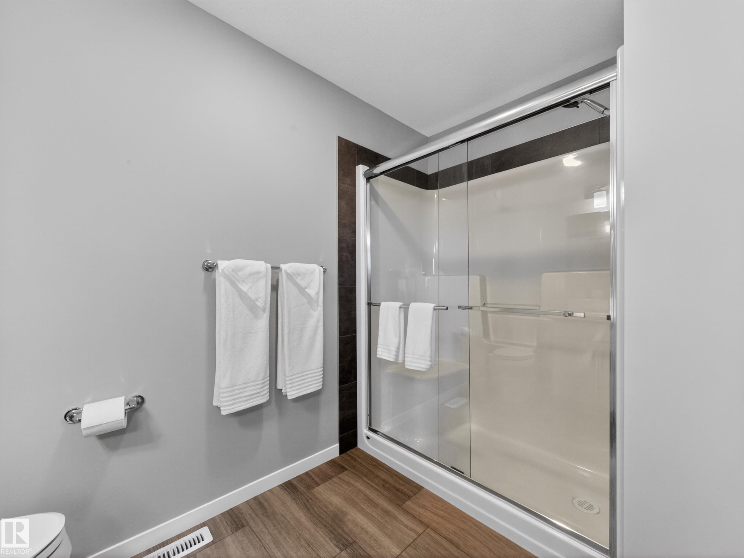 Shower enclosure with sliding glass doors, chrome hardware, and a white shower base - 323 Balsam Link, Leduc, AB - Indoor Photo Showing Bathroom