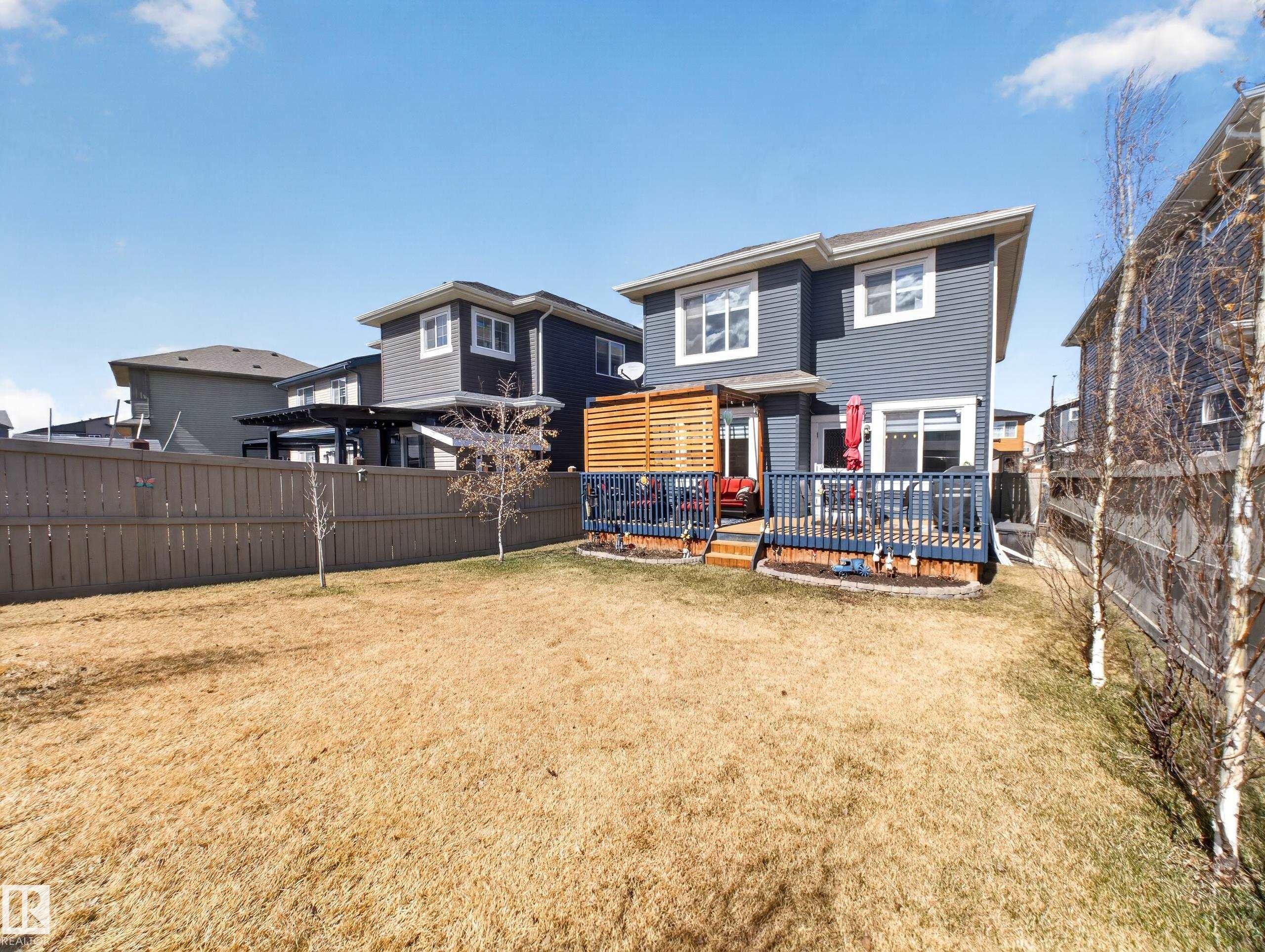 Spacious backyard featuring a multi-level deck with a privacy screen, perimeter fencing, and established saplings - 323 Balsam Link, Leduc, AB - Outdoor With Deck Patio Veranda