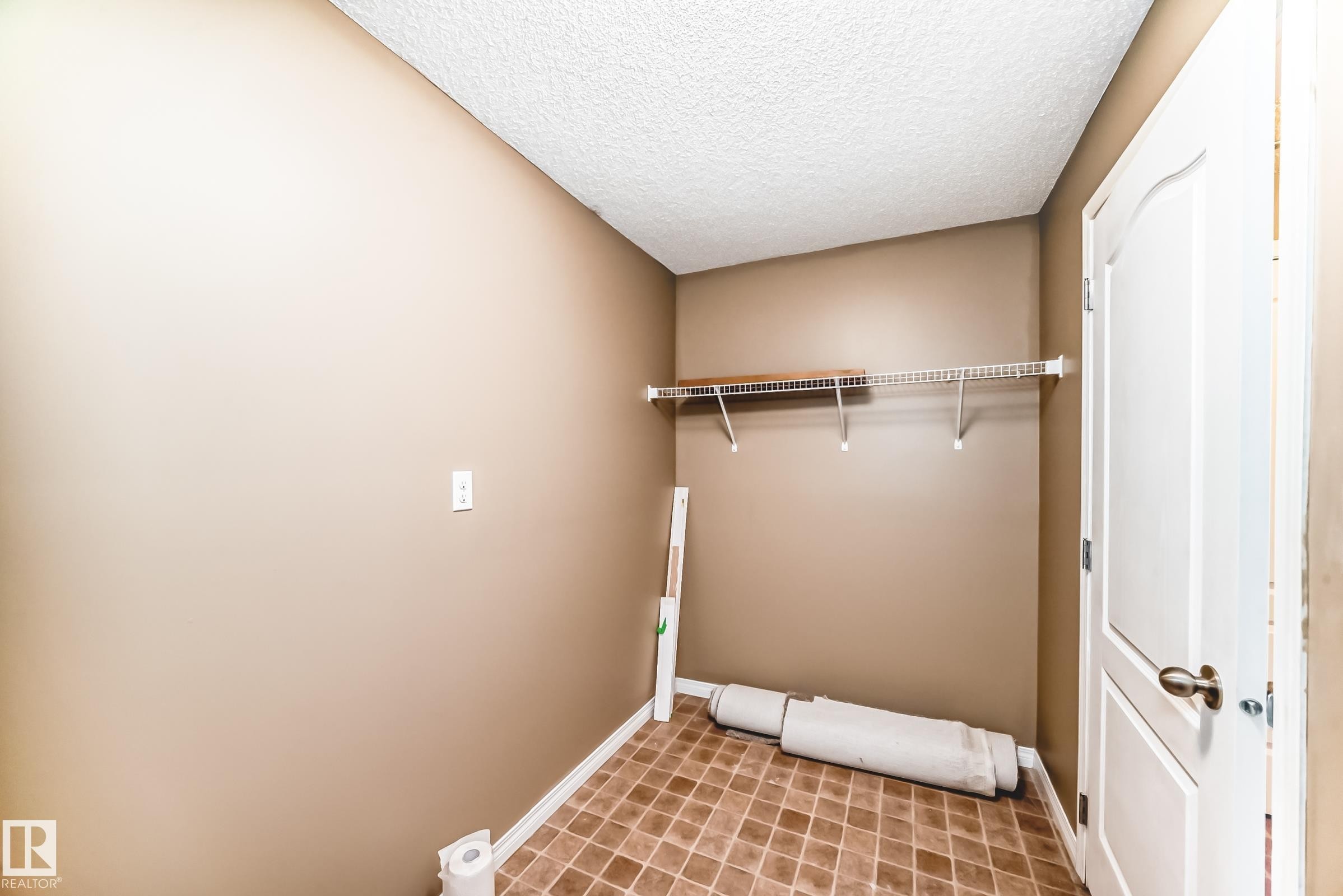 Utility space with neutral-toned walls, textured ceiling, and tiled flooring - 344 1520 Hammond Gate Gate, Edmonton, AB - Indoor Photo Showing Other Room