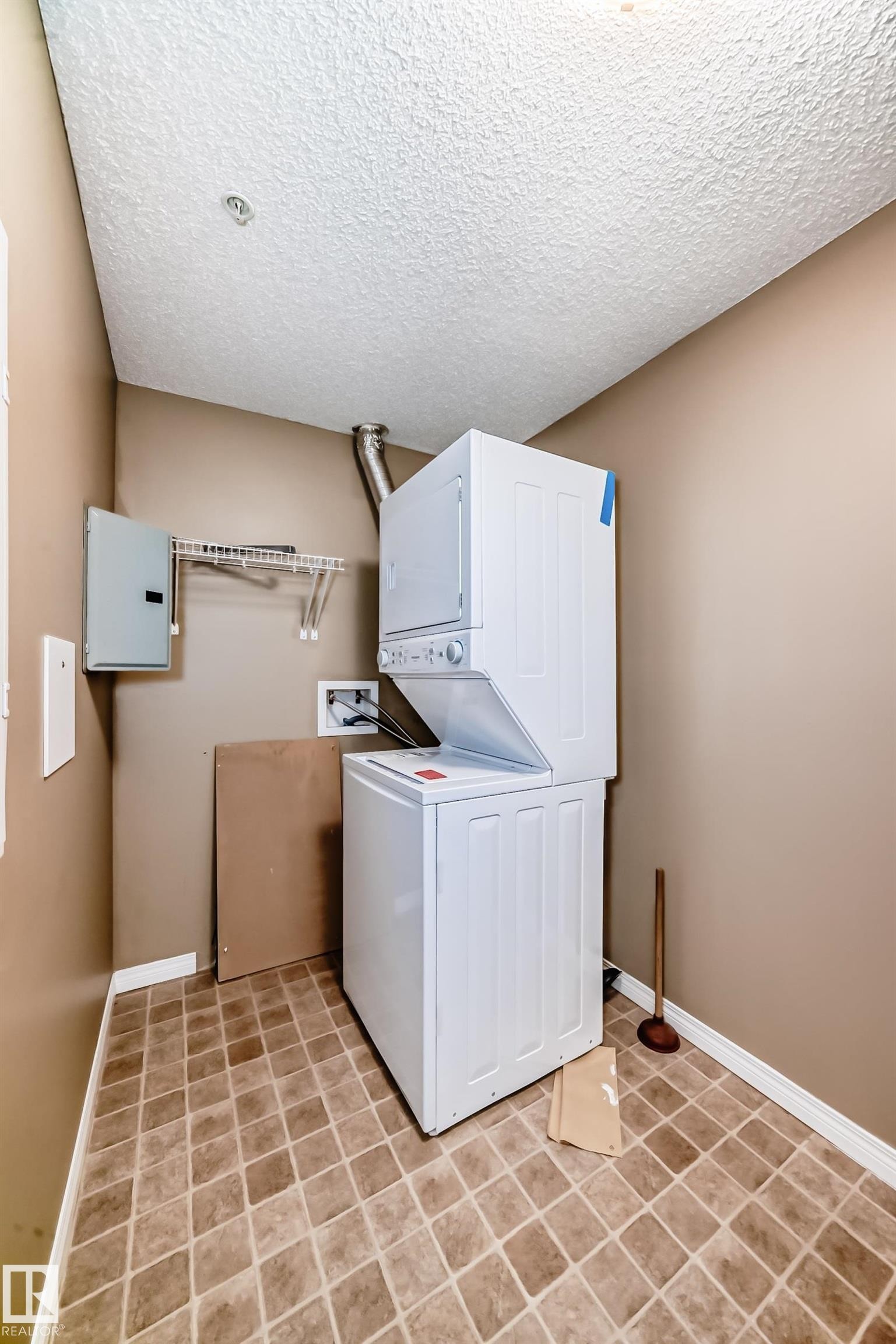 Dedicated laundry area featuring a stacked white washer and dryer unit - 344 1520 Hammond Gate Gate, Edmonton, AB - Indoor Photo Showing Laundry Room