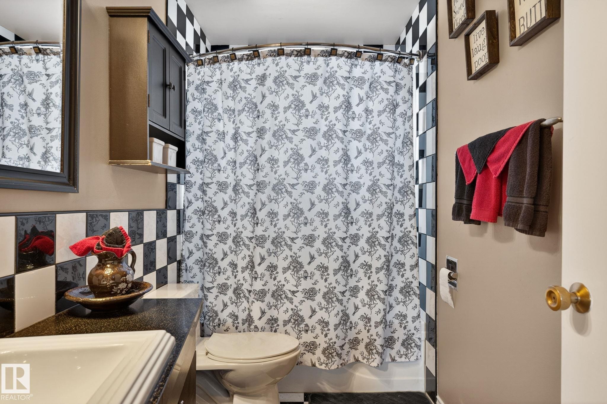Bathroom featuring checkered tile wainscoting and coordinating shower surround - 9112 130 Avenue, Edmonton, AB - Indoor Photo Showing Bathroom
