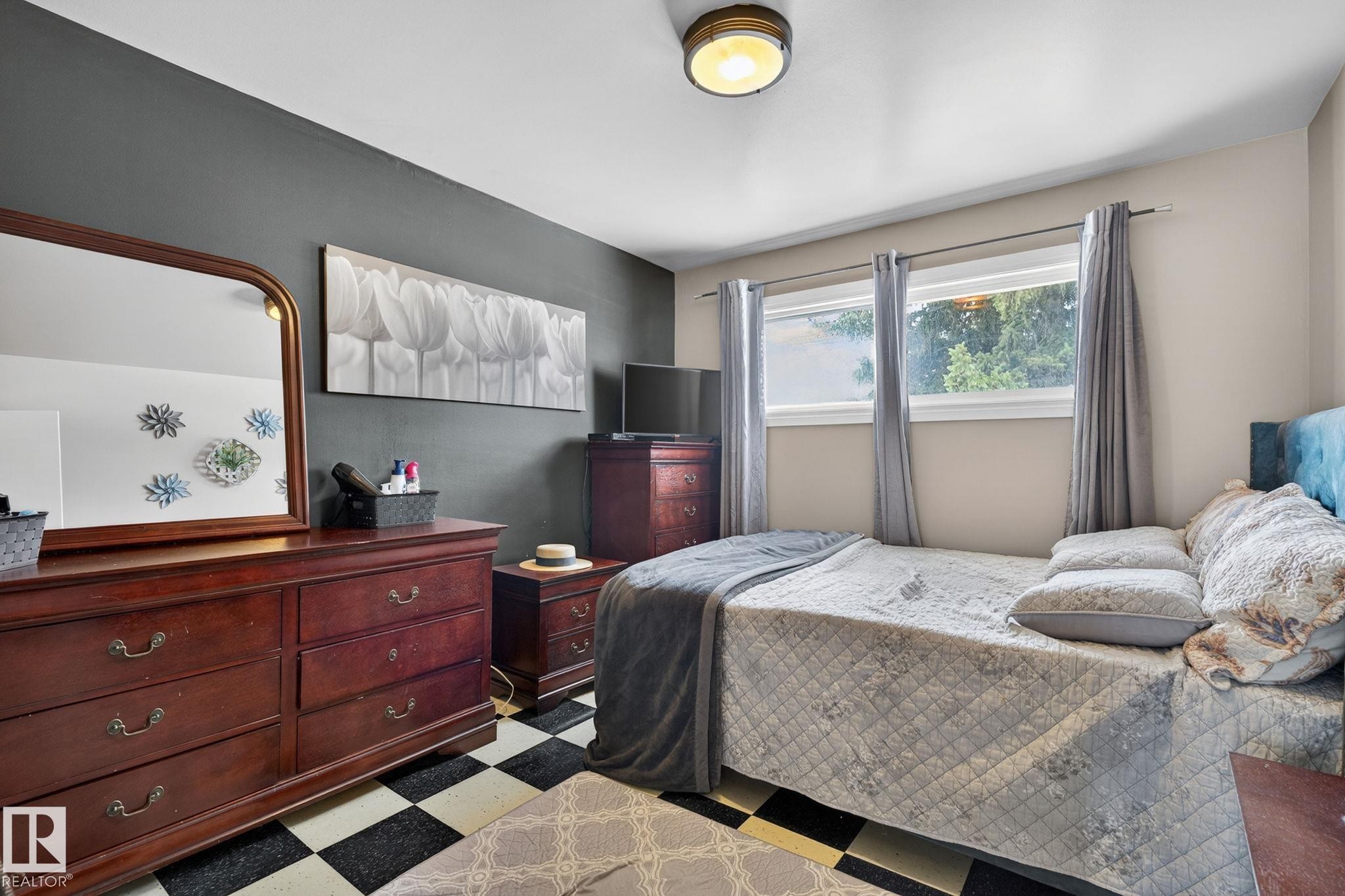Room featuring a two-tone wall design, a checkered tile floor, and a flush-mount ceiling light fixture - 9112 130 Avenue, Edmonton, AB - Indoor Photo Showing Bedroom