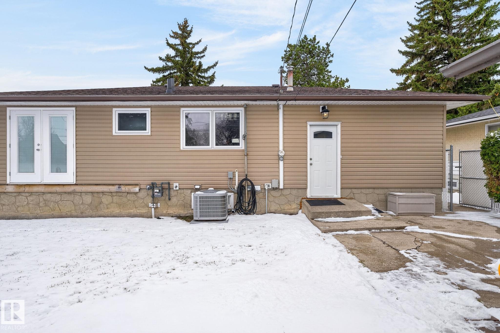 Rear exterior featuring tan horizontal siding and a brown shingle roof - 9112 130 Avenue, Edmonton, AB - Outdoor