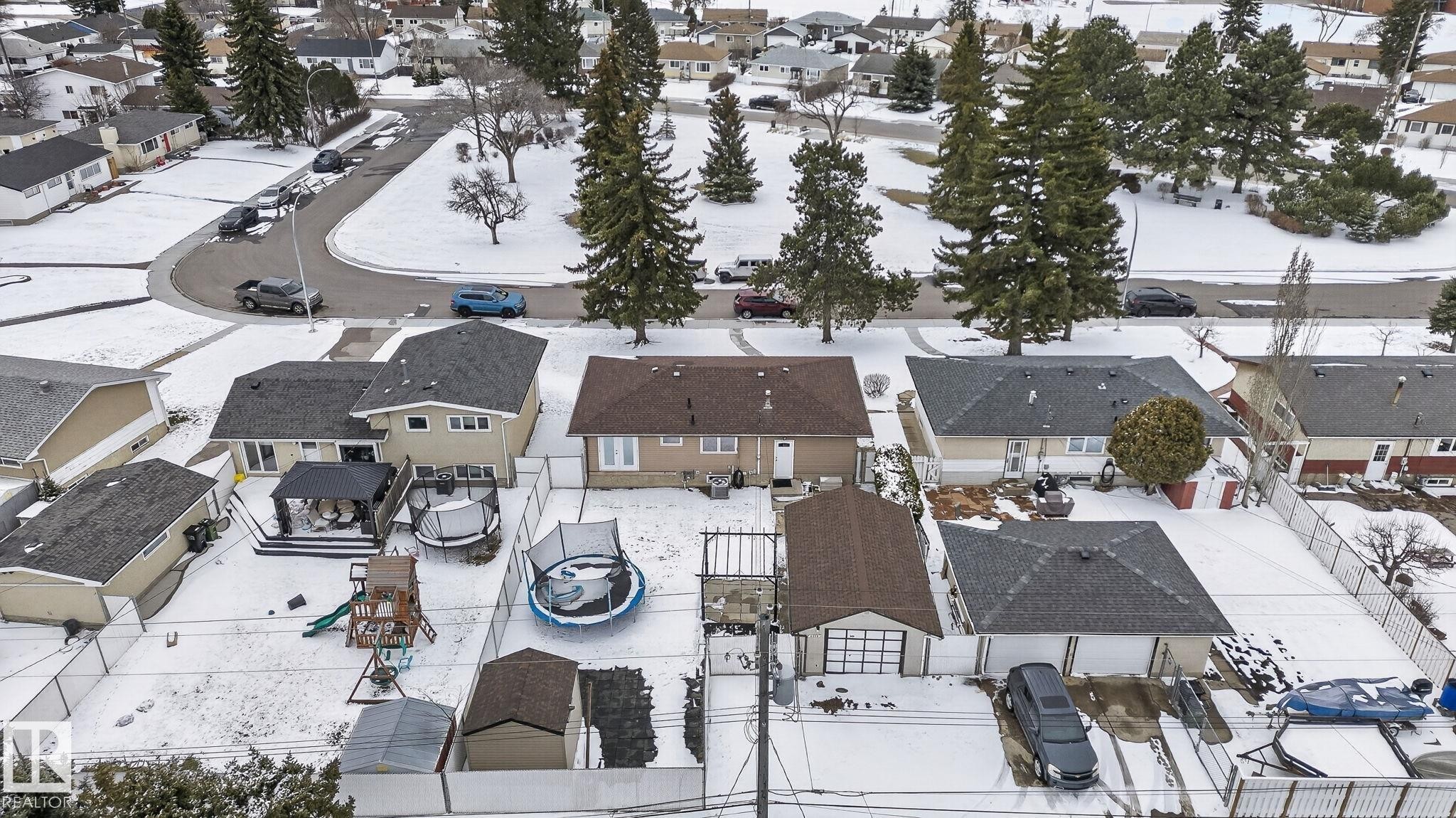 Spacious residential property featuring a large backyard, multiple outbuildings, and mature trees - 9112 130 Avenue, Edmonton, AB - Outdoor With View