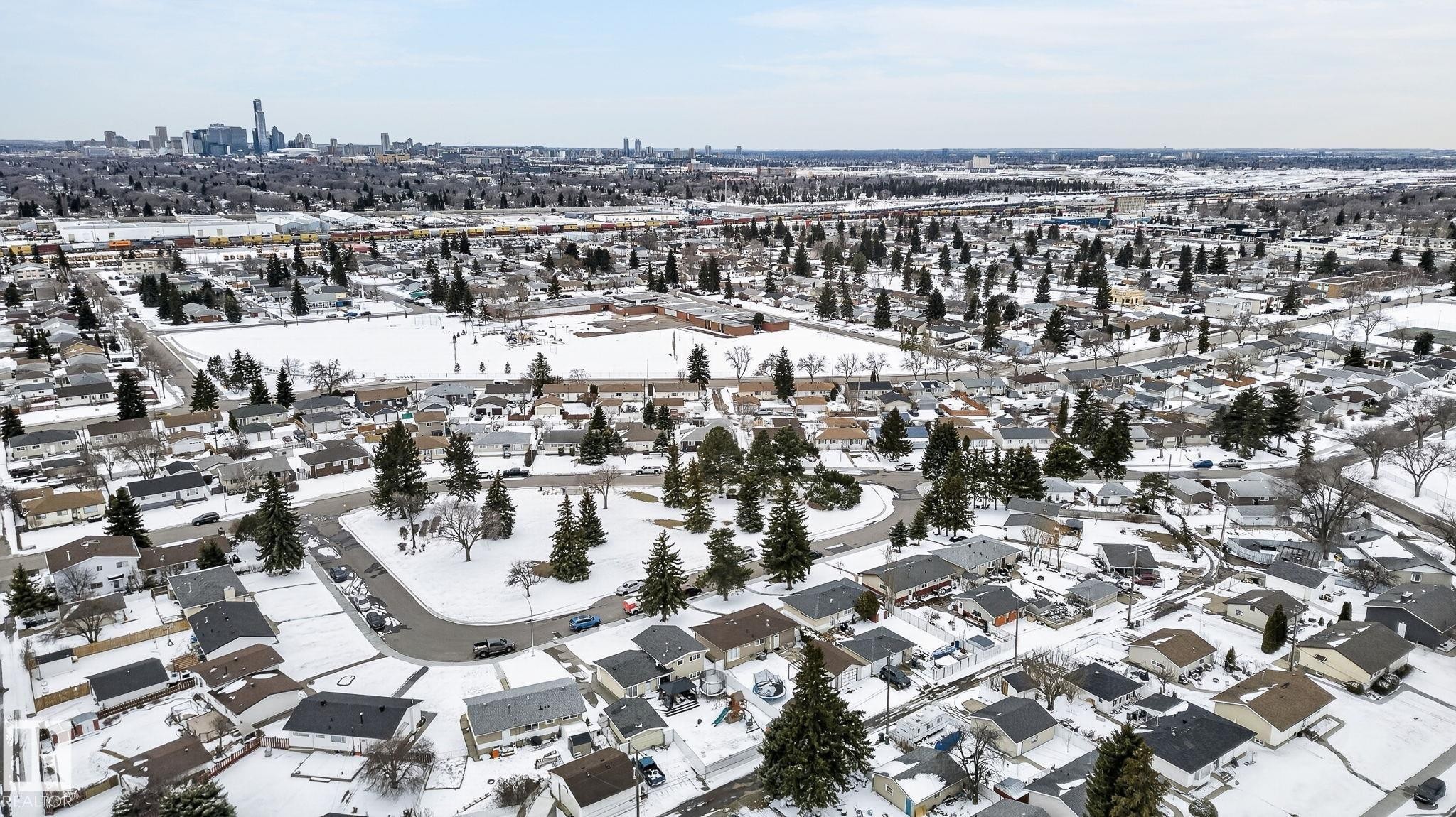Aerial perspective showcasing a residential neighborhood with a distant cityscape - 9112 130 Avenue, Edmonton, AB - Outdoor With View