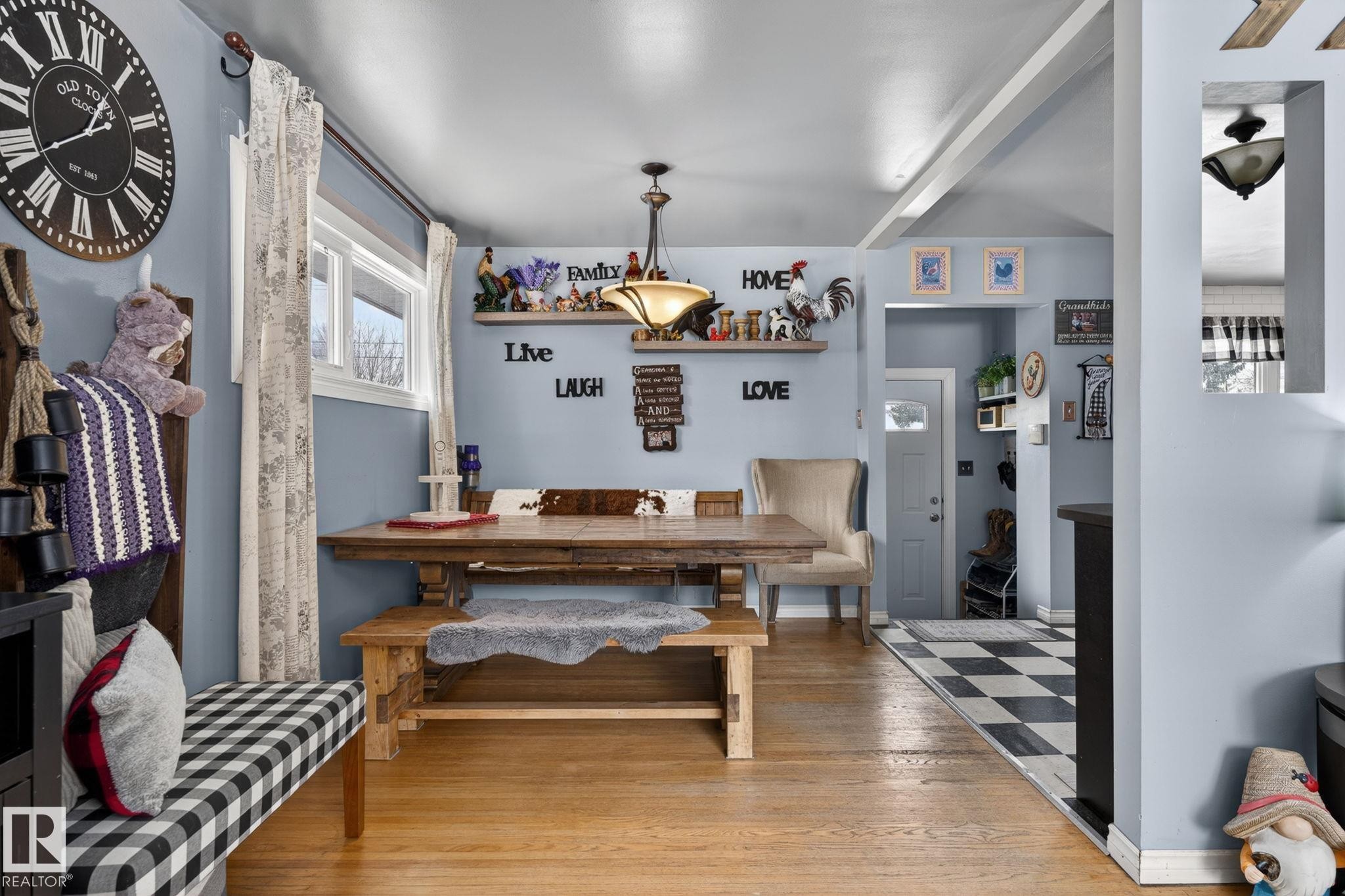 Dining area featuring wood-finish flooring, a contemporary chandelier, two windows, and built-in shelving - 9112 130 Avenue, Edmonton, AB - Indoor Photo Showing Other Room