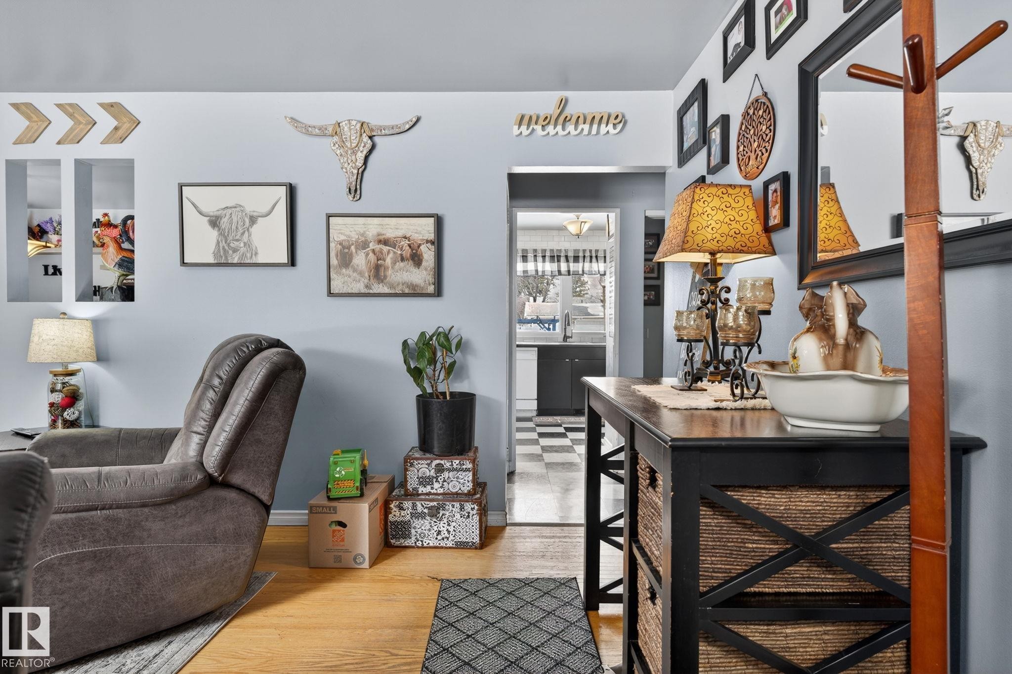 Hardwood-finish flooring extending into the hallway and a passageway to a kitchen with checkerboard flooring - 9112 130 Avenue, Edmonton, AB - Indoor Photo Showing Other Room