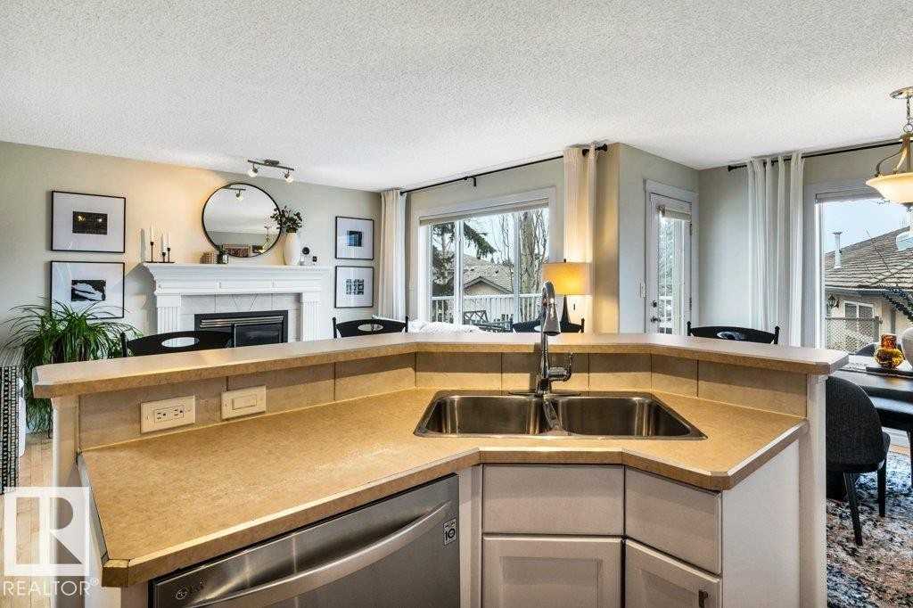 23 211 Blackburn Drive E, Edmonton, AB - Indoor Photo Showing Kitchen With Fireplace With Double Sink
