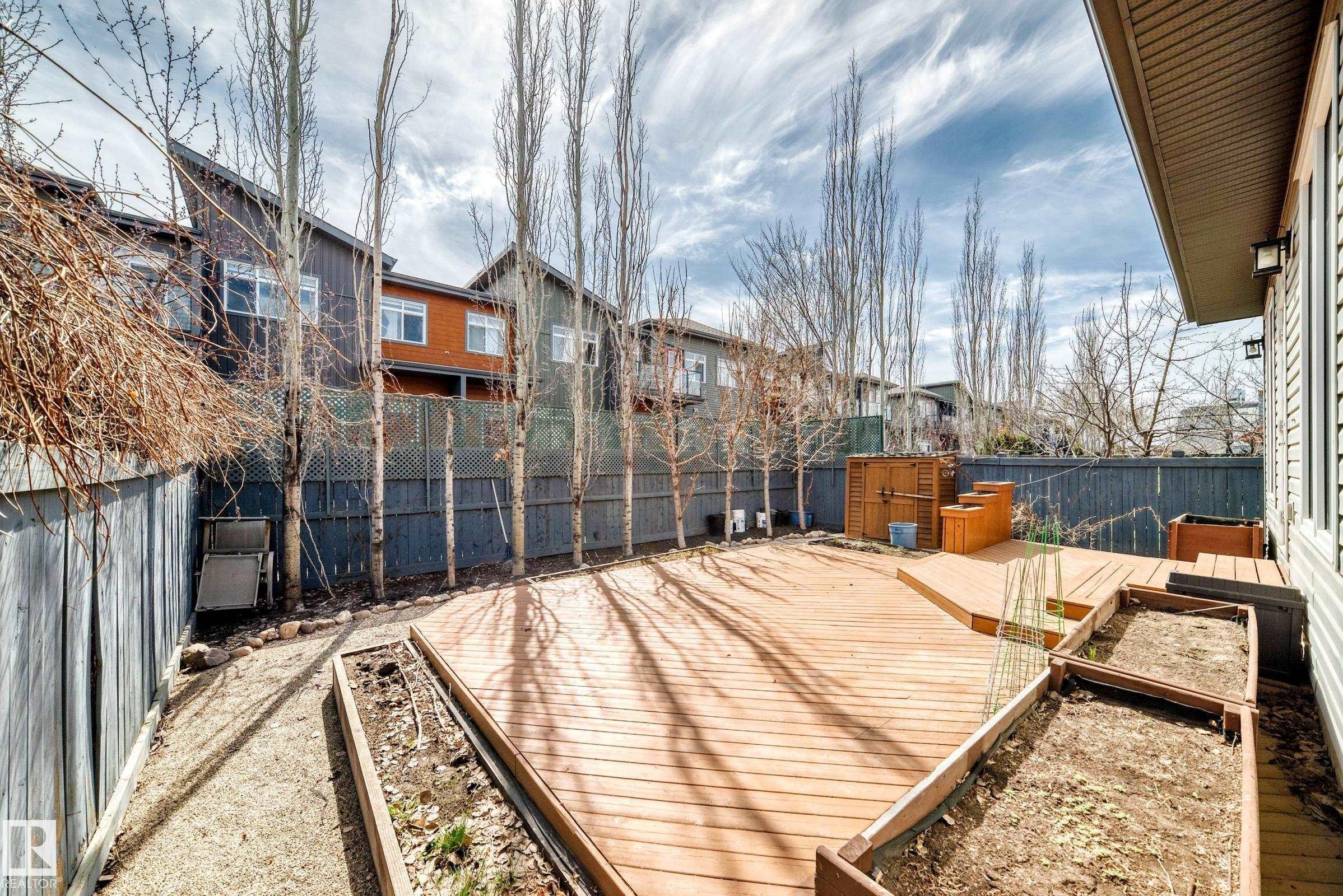 Expansive exterior deck featuring a multi-level design, built-in planter boxes, privacy fencing, and exterior wall lighting - 7719 Getty Wynd, Edmonton, AB