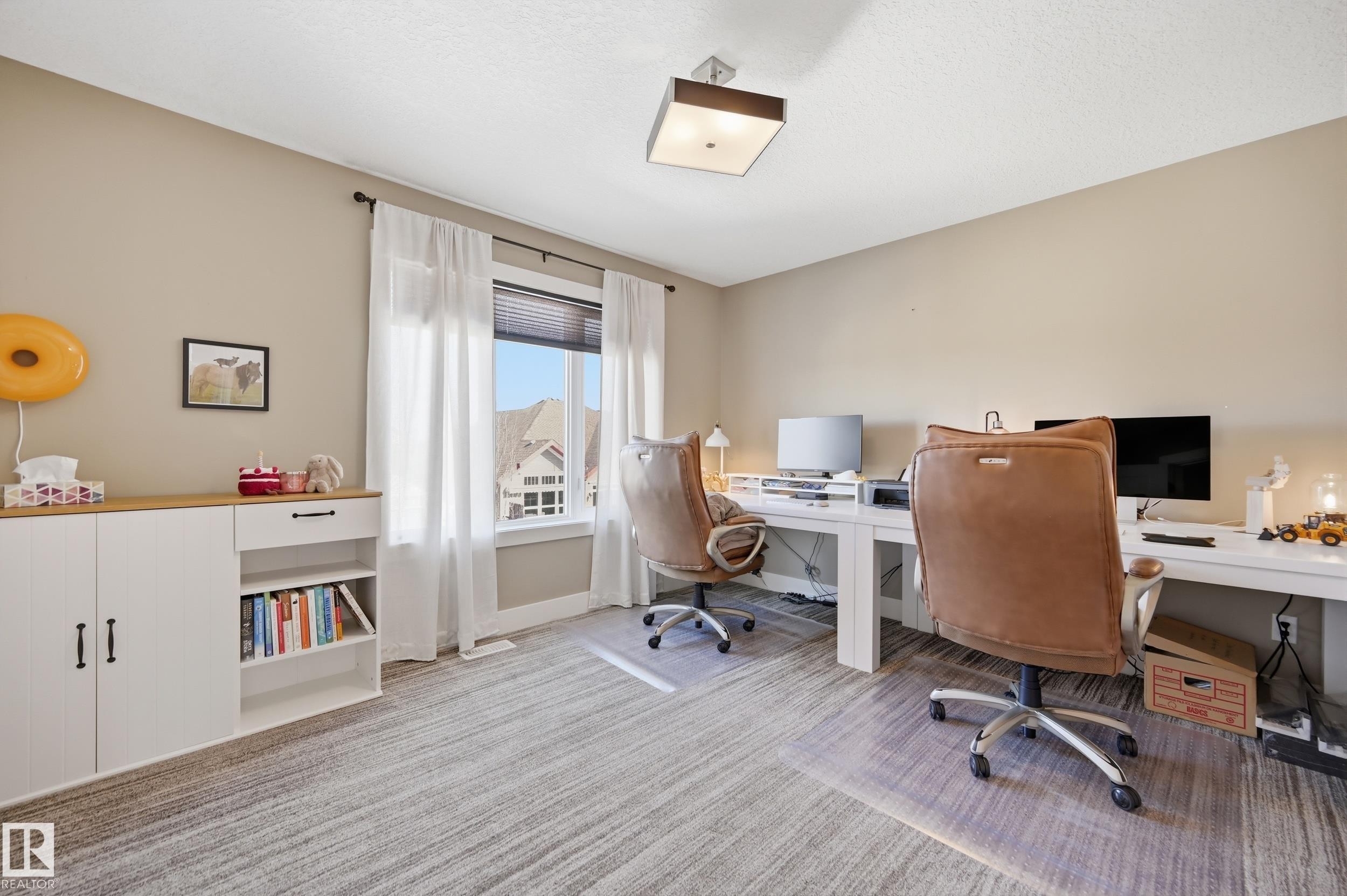 This versatile room features neutral-toned walls, light-colored flooring, and a large window with white curtains and blinds providing natural light - 2018 Armitage Green, Edmonton, AB - Indoor Photo Showing Office