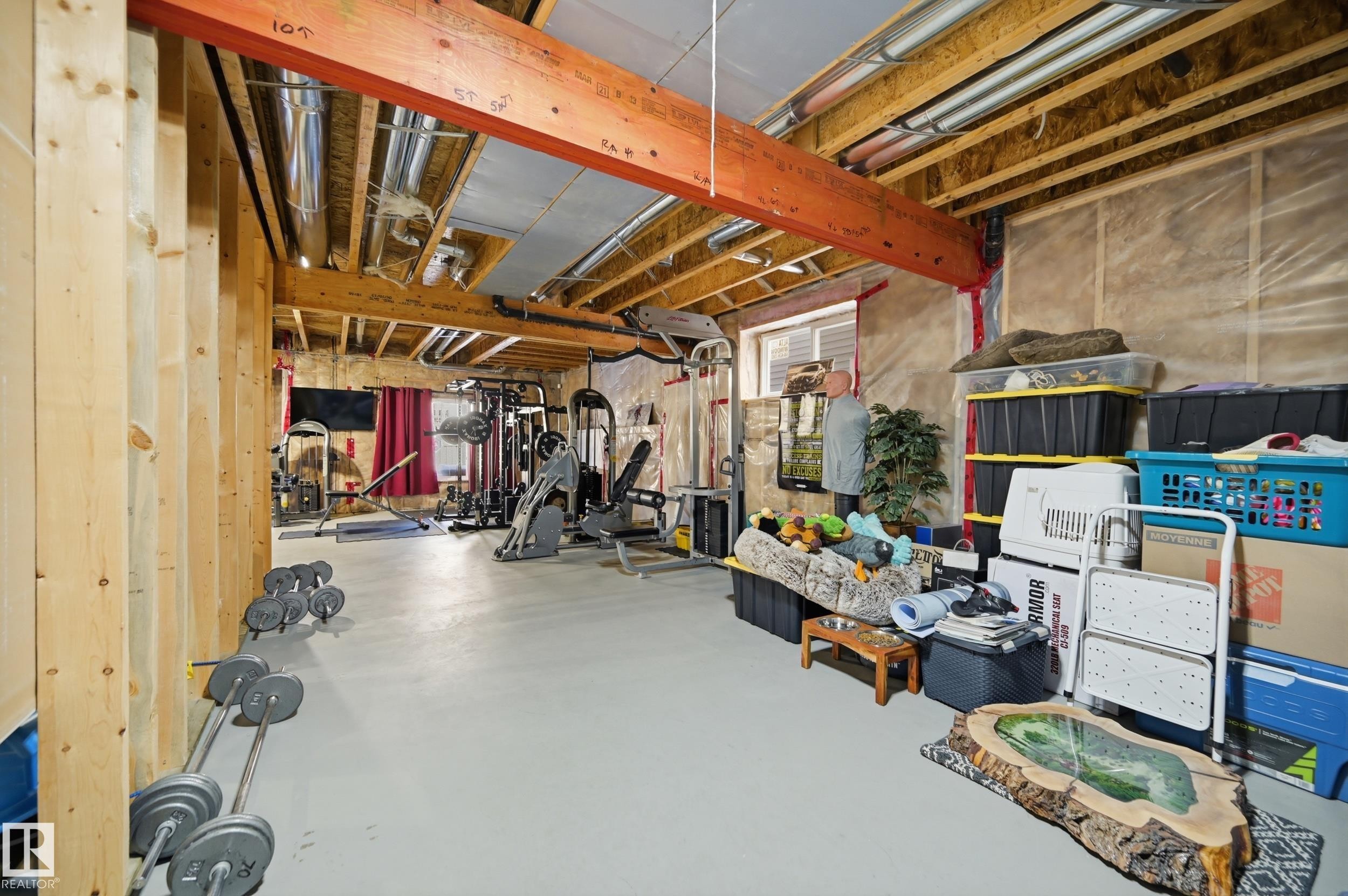 Spacious unfinished basement with exposed wood framing and ceiling joists, offering potential for customization - 2018 Armitage Green, Edmonton, AB - Indoor Photo Showing Gym Room