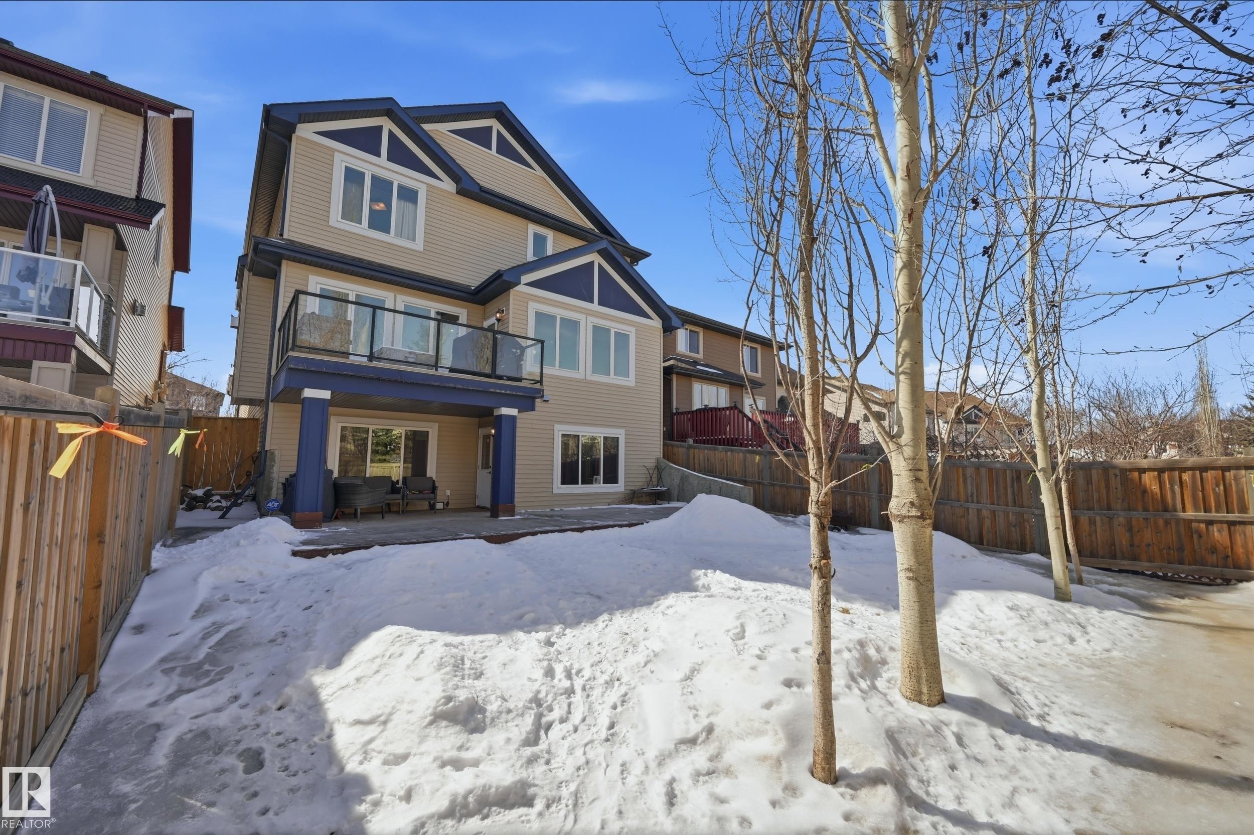This property features a spacious rear yard with a patio, a deck, and mature trees - 2018 Armitage Green, Edmonton, AB - Outdoor