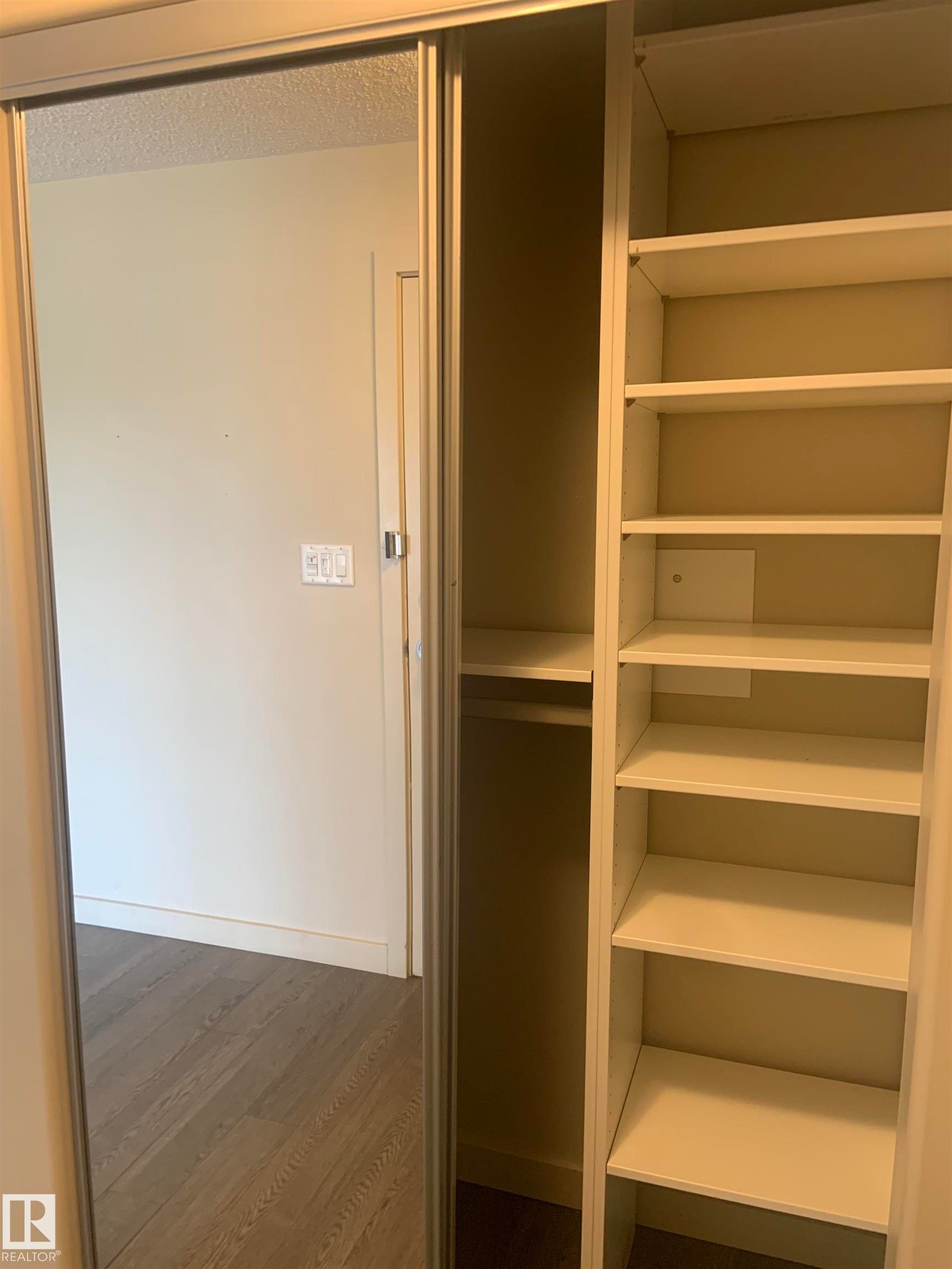Built-in closet system featuring multiple shelving units and a hanging rod - 307 6084 Stanton Drive, Edmonton, AB - Indoor With Storage