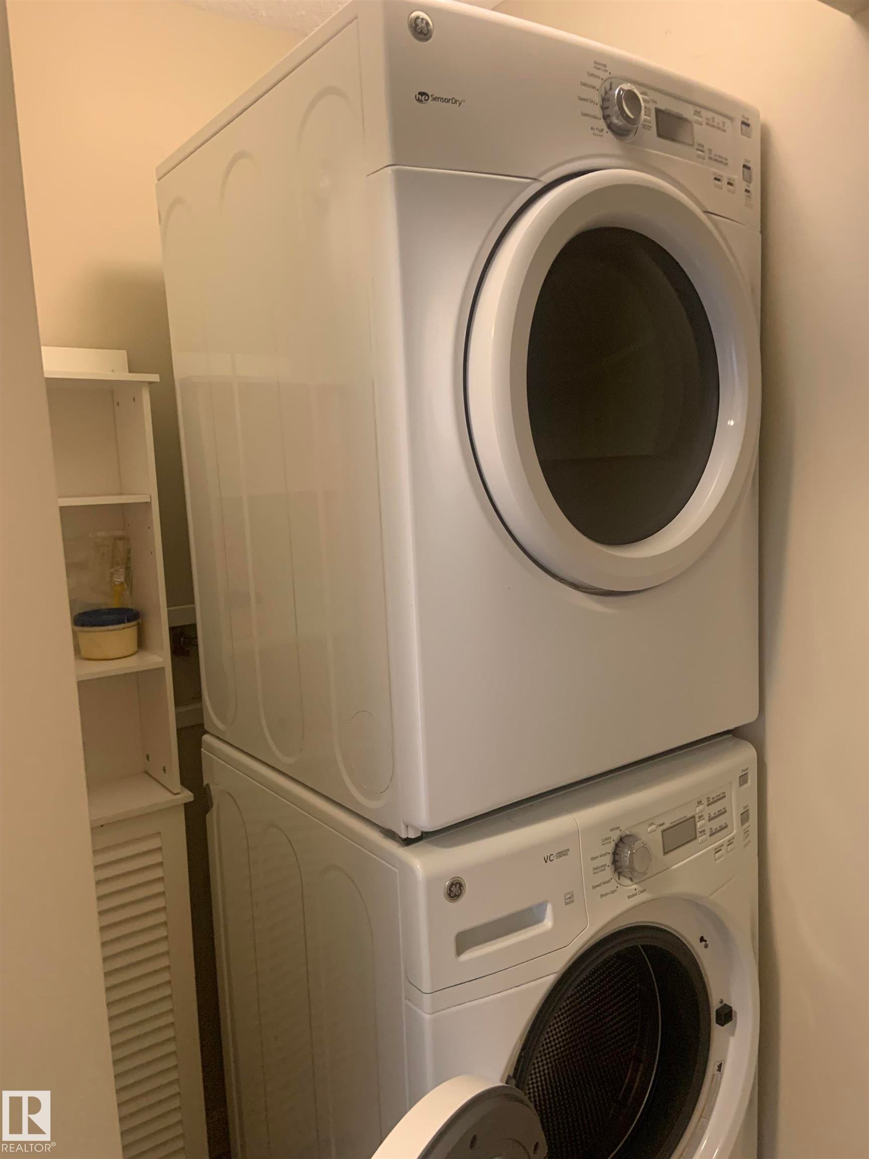 Stacked white front-loading washer and dryer units - 307 6084 Stanton Drive, Edmonton, AB - Indoor Photo Showing Laundry Room