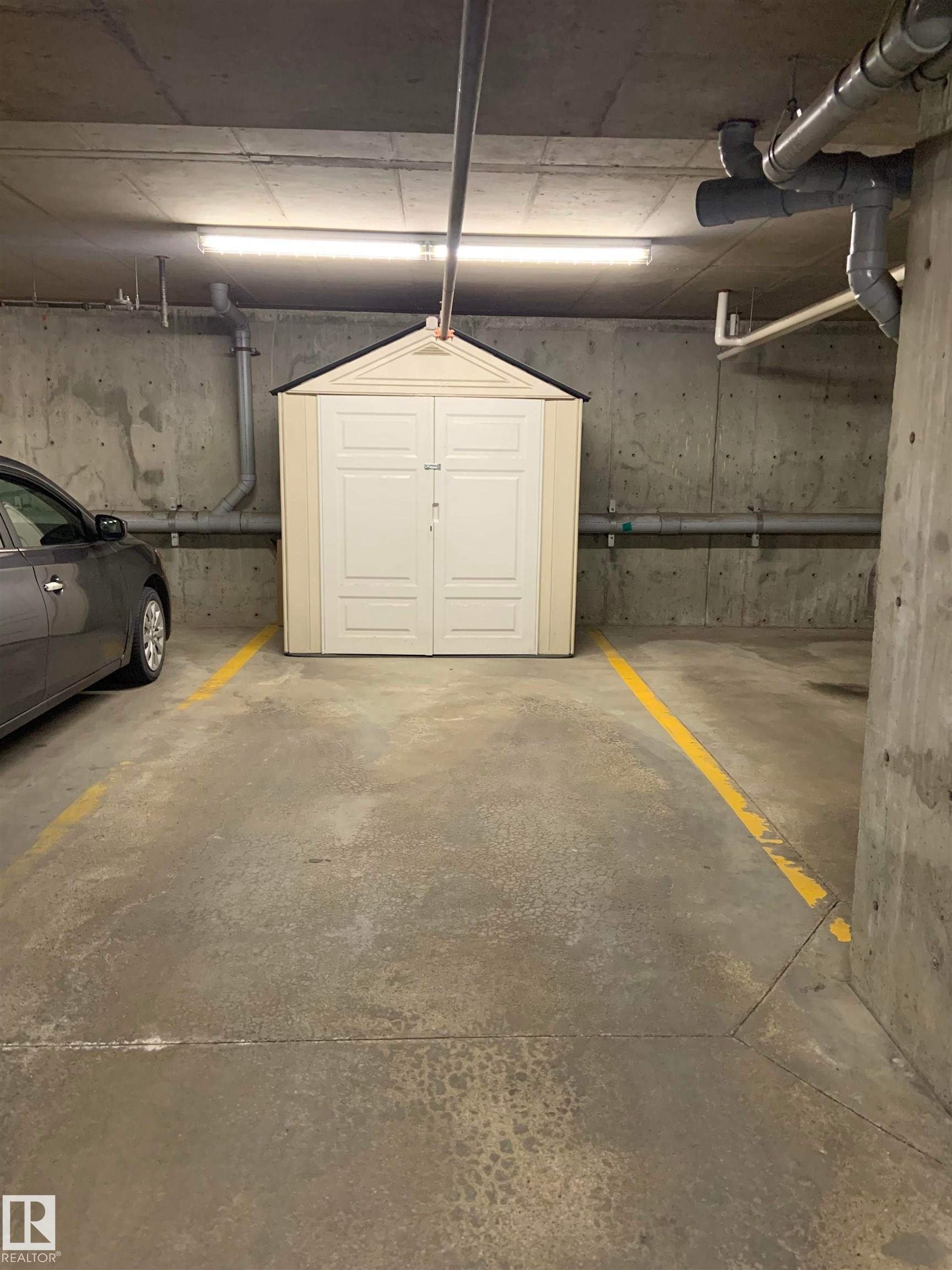 Dedicated parking space with a personal storage shed featuring double doors and a gabled roof - 307 6084 Stanton Drive, Edmonton, AB - Indoor Photo Showing Garage