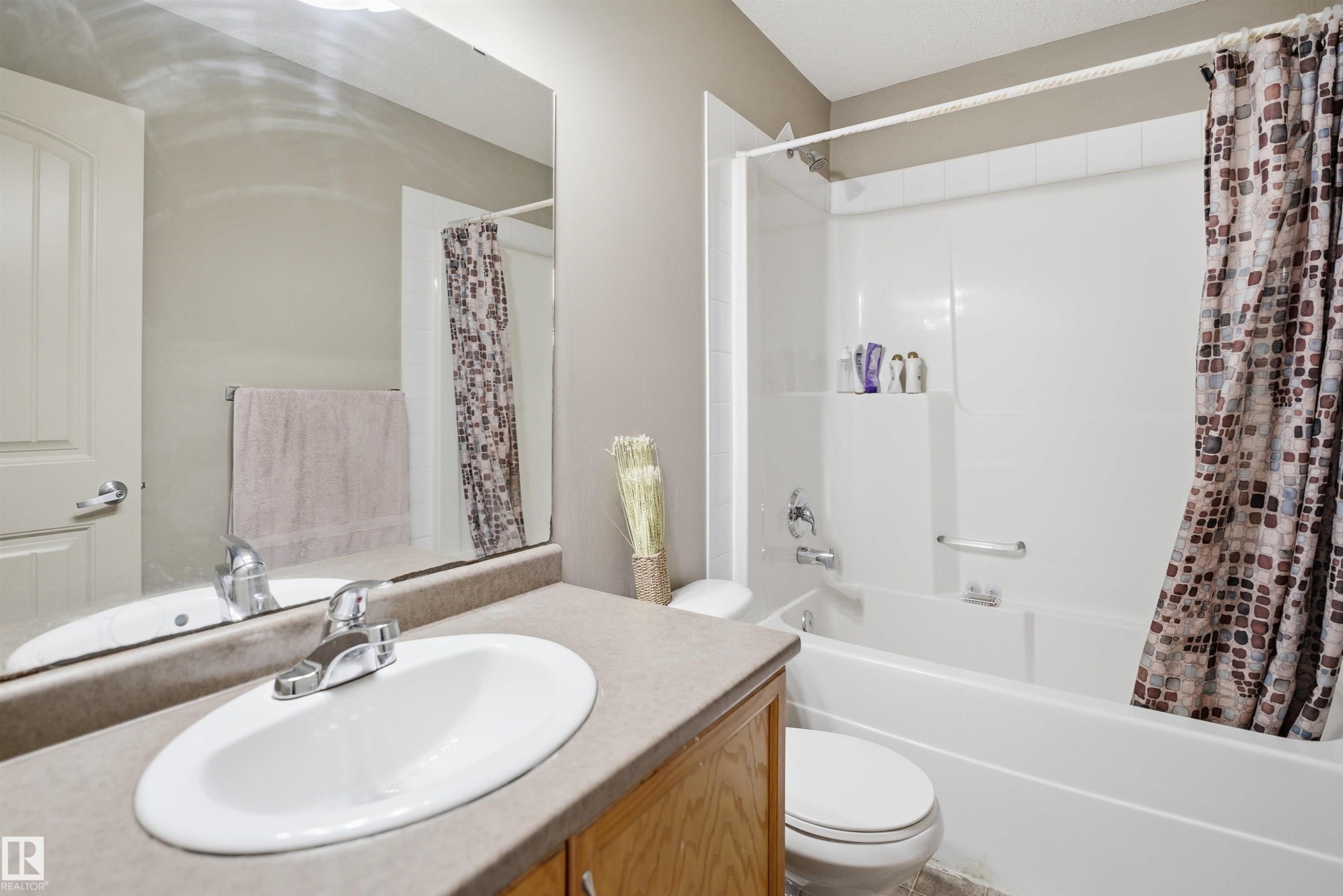 Bathroom featuring a single vanity with a laminate countertop, an undermount sink, and a chrome faucet - 3533 11 Street, Edmonton, AB