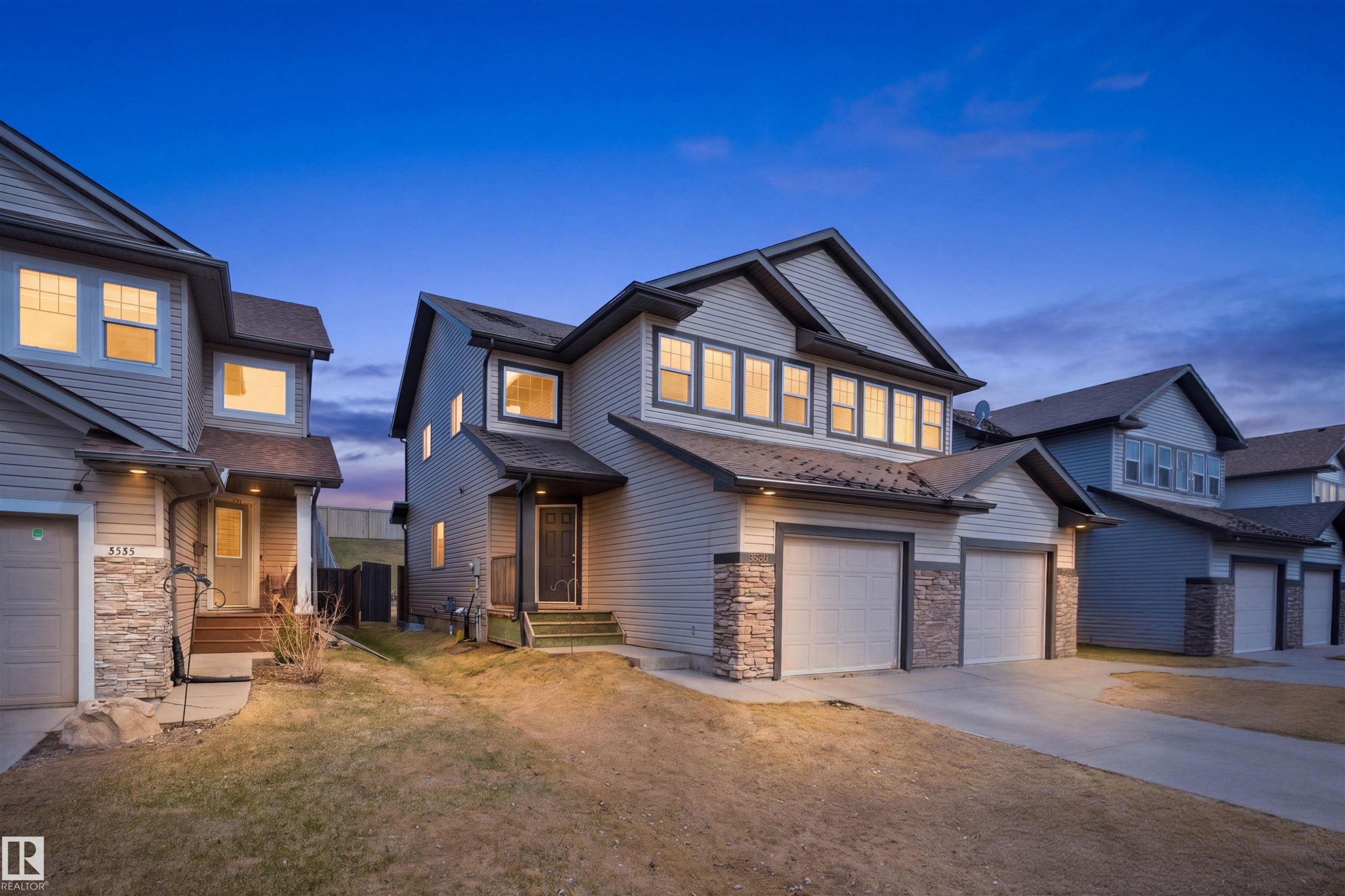 Modern two-story residence featuring light-toned siding and stone veneer accents - 3533 11 Street, Edmonton, AB