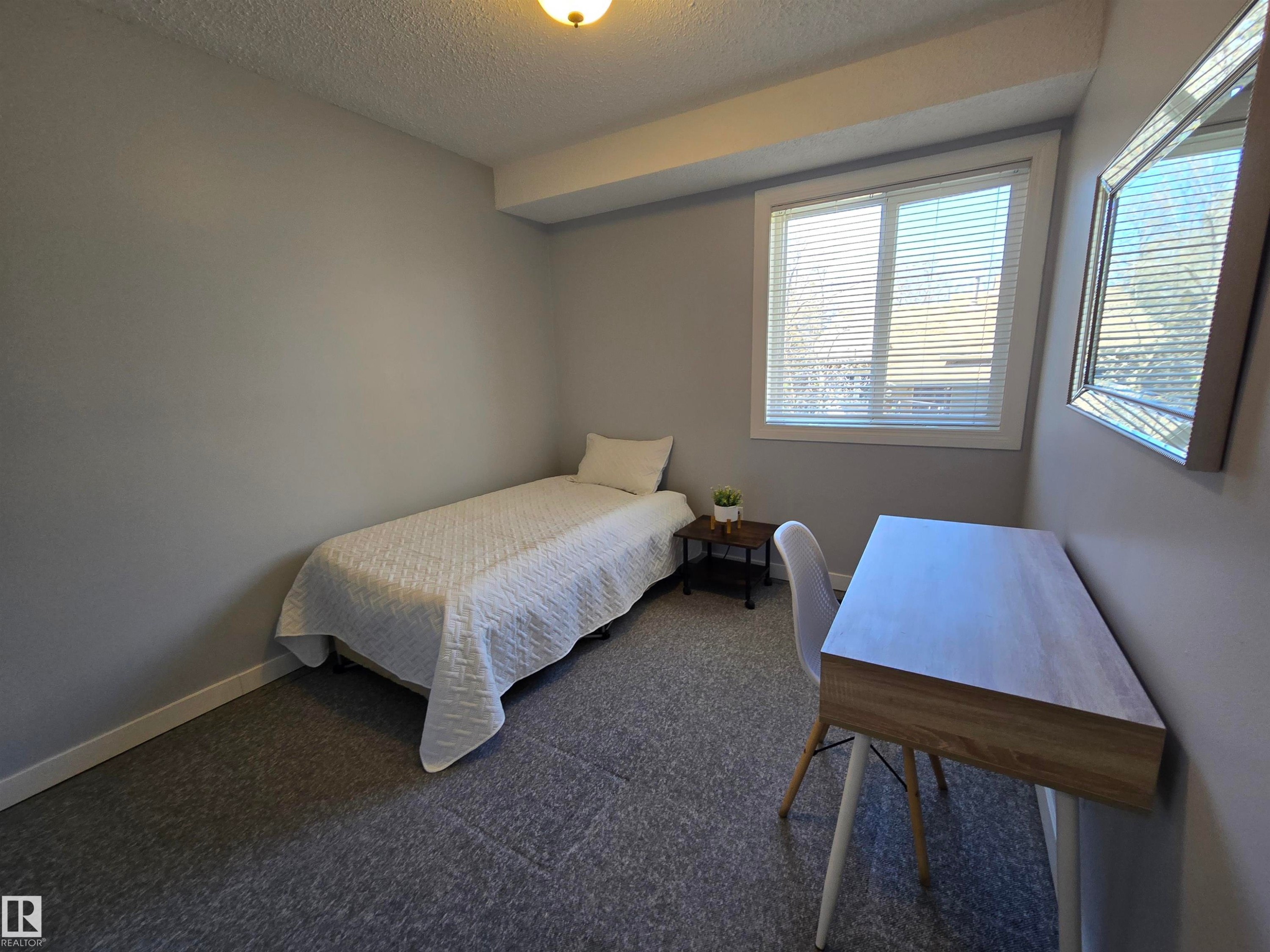 Recessed window with white blinds - 202 24 Alpine Place, St. Albert, AB - Indoor Photo Showing Bedroom