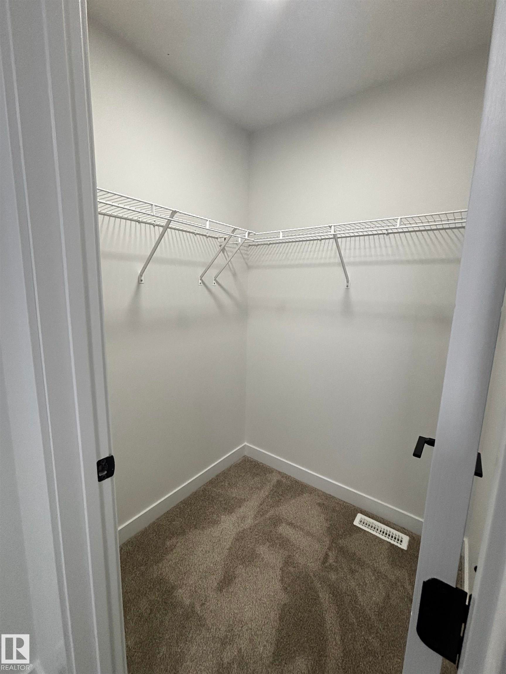 The property features a closet with carpeted flooring and white wire shelving - 2012 210 St, Edmonton, AB - Indoor With Storage