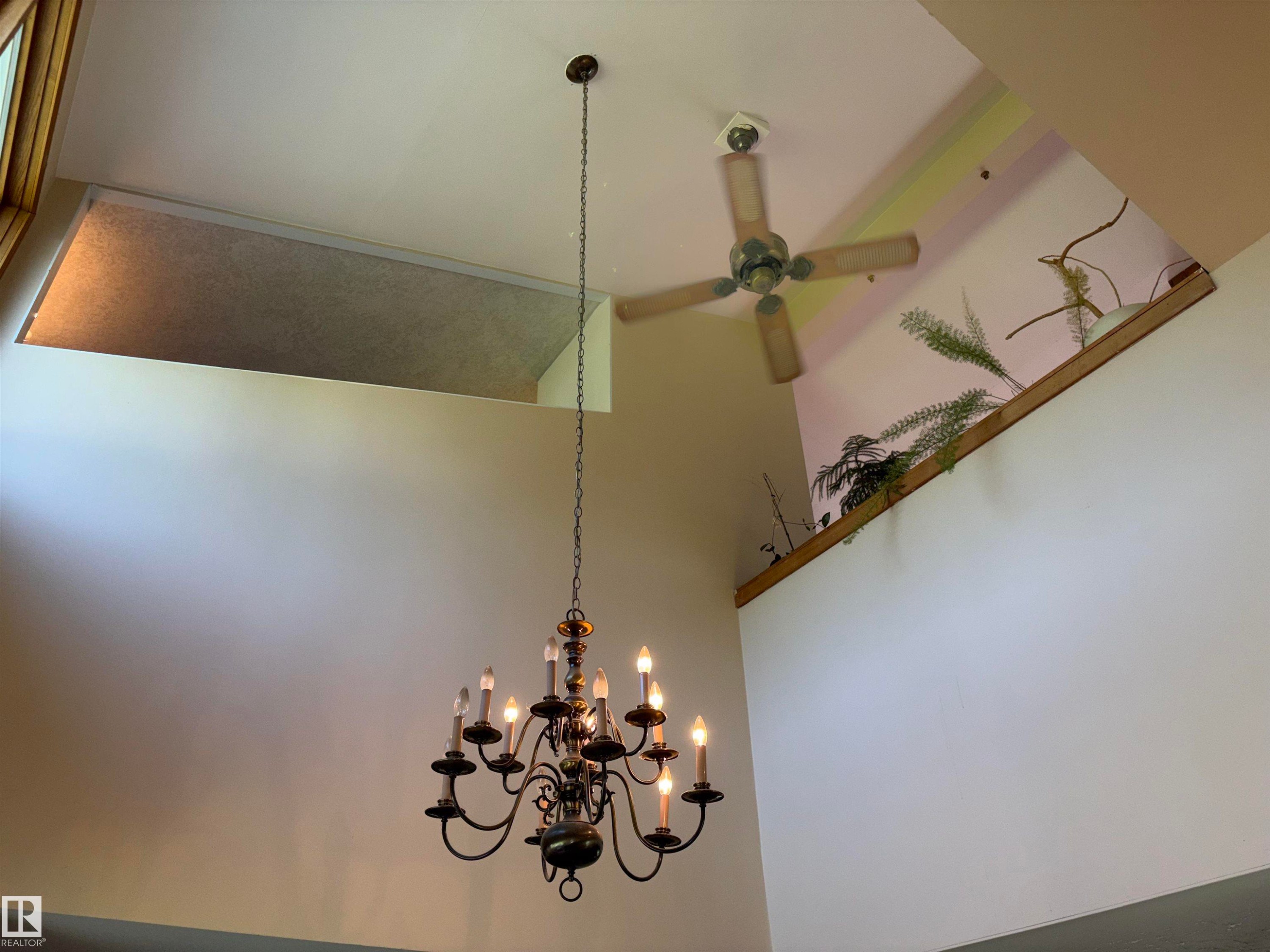 Vaulted ceiling featuring a multi-arm chandelier, wood-blade ceiling fan, and high-set windows - 8812 146 Street, Edmonton, AB