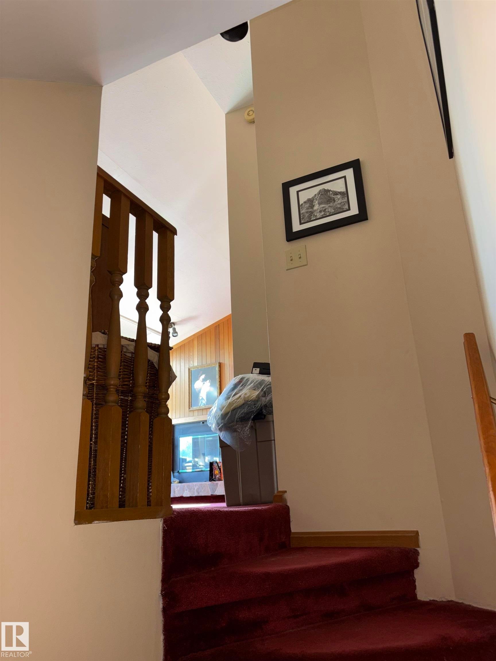 Staircase featuring red carpeting and a wood-finish banister - 8812 146 Street, Edmonton, AB