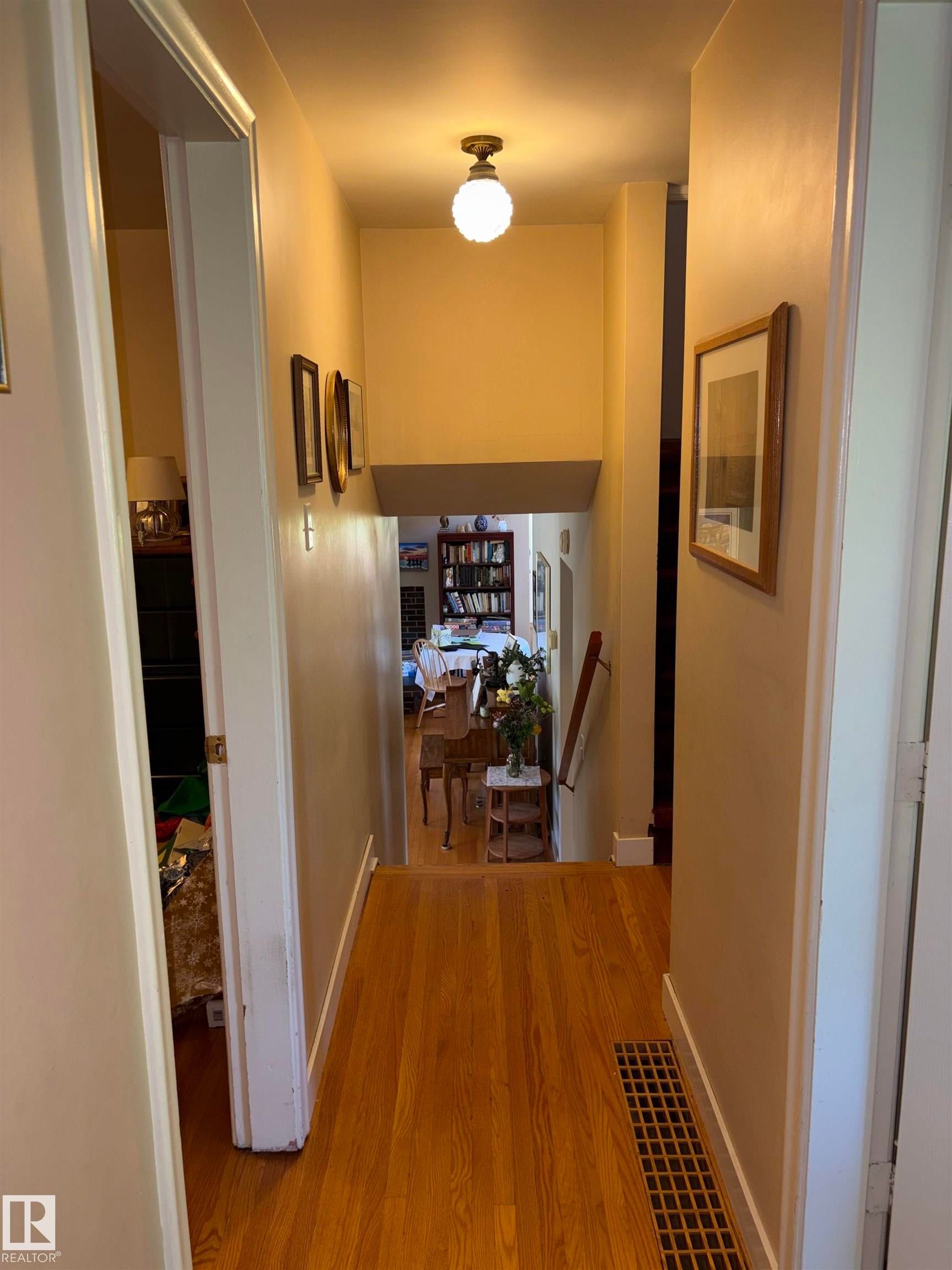 Hardwood flooring extends throughout this hallway with a traditional flush mount light fixture - 8812 146 Street, Edmonton, AB