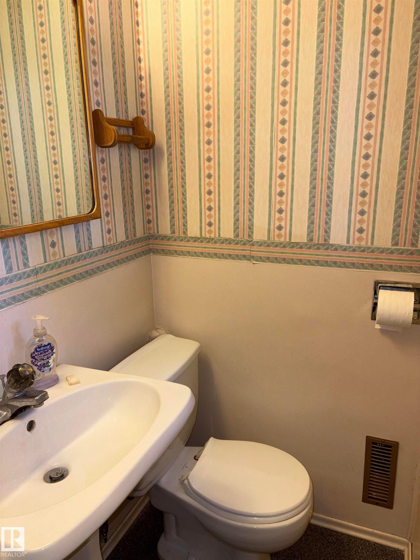 Pedestal sink with a two-handle faucet and a wall-mounted mirror - 8812 146 Street, Edmonton, AB