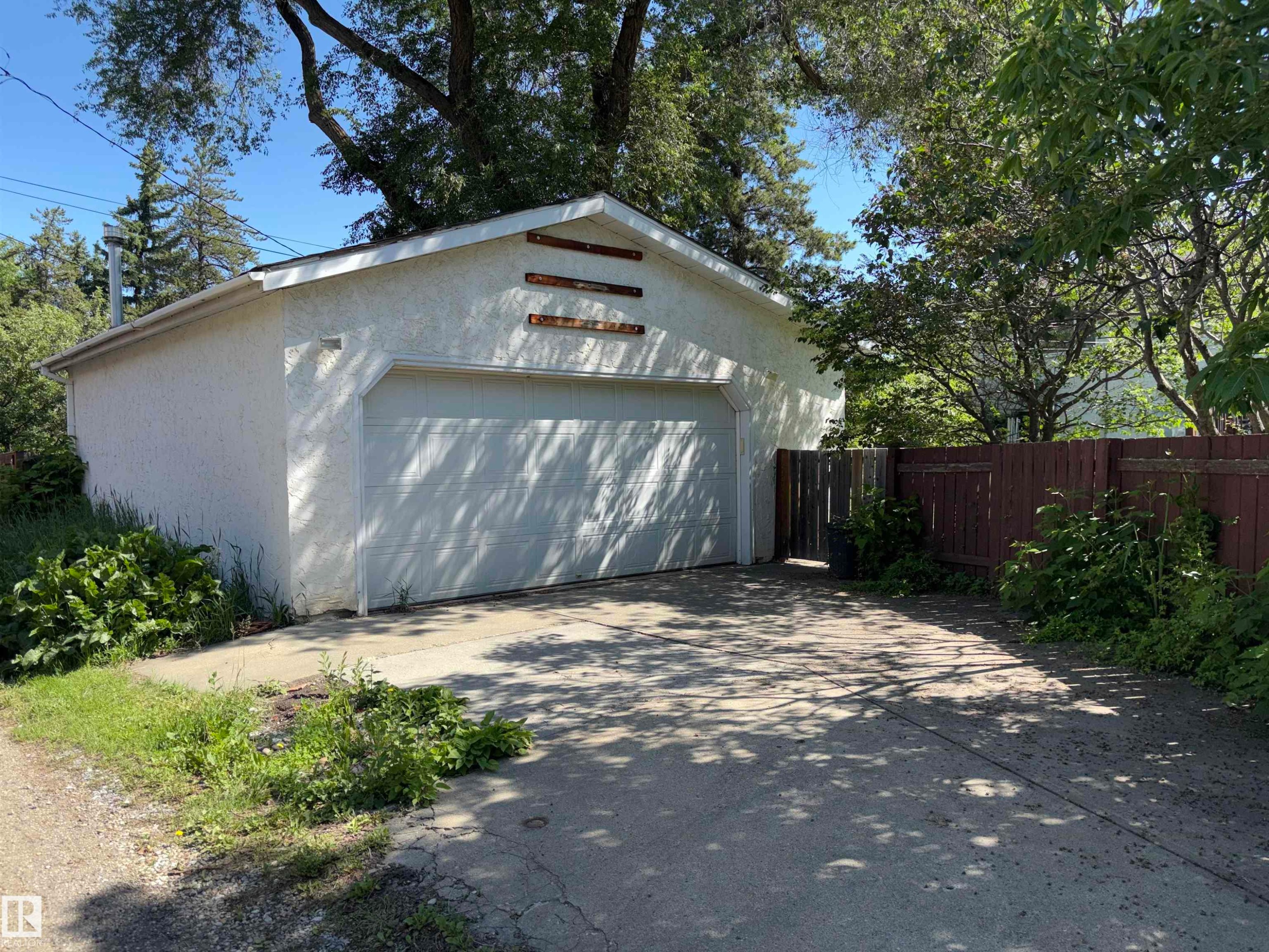 Detached garage with a paneled overhead door and stucco exterior finish - 8812 146 Street, Edmonton, AB