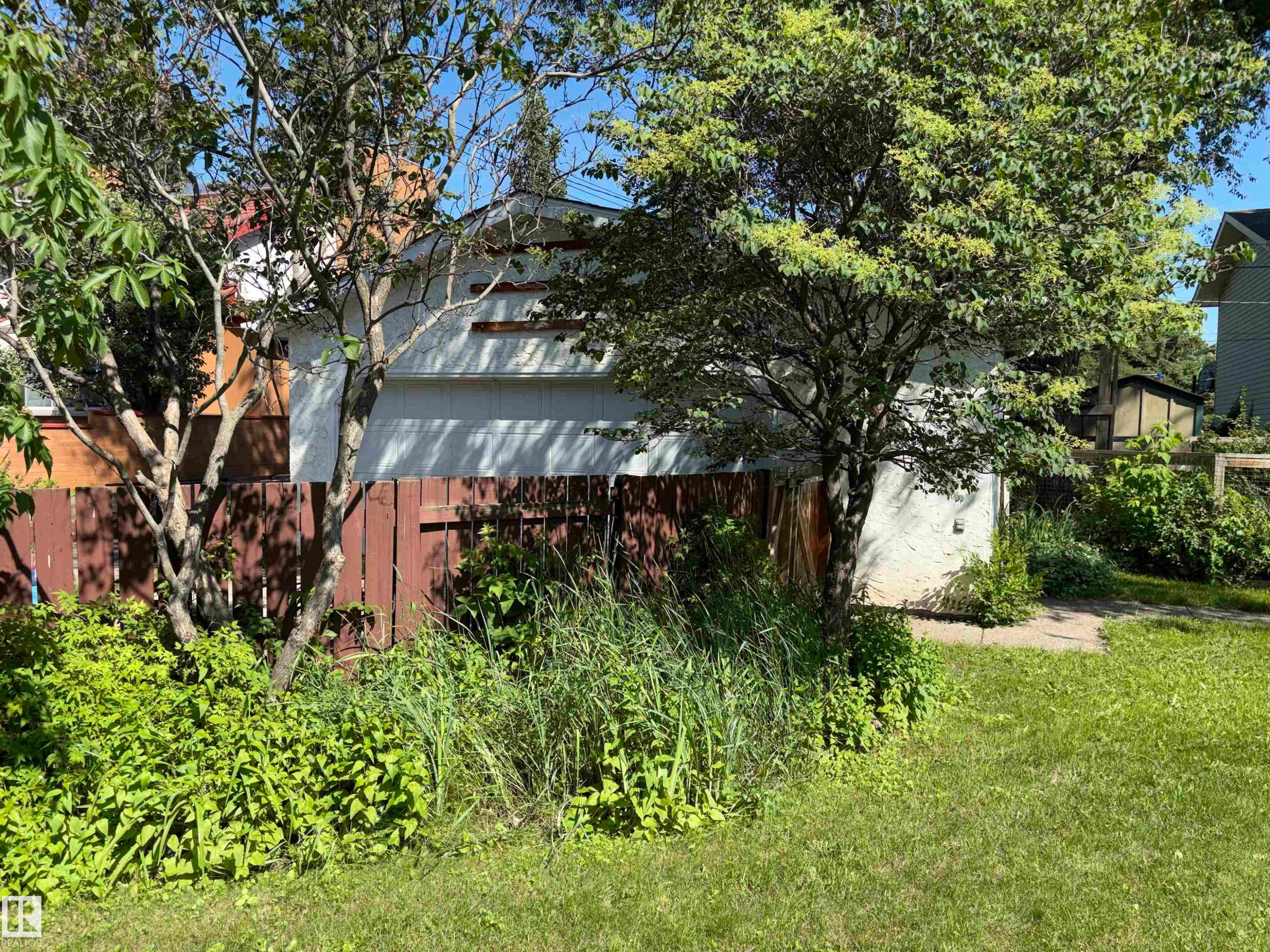 Fenced perimeter featuring mature trees and established greenery - 8812 146 Street, Edmonton, AB