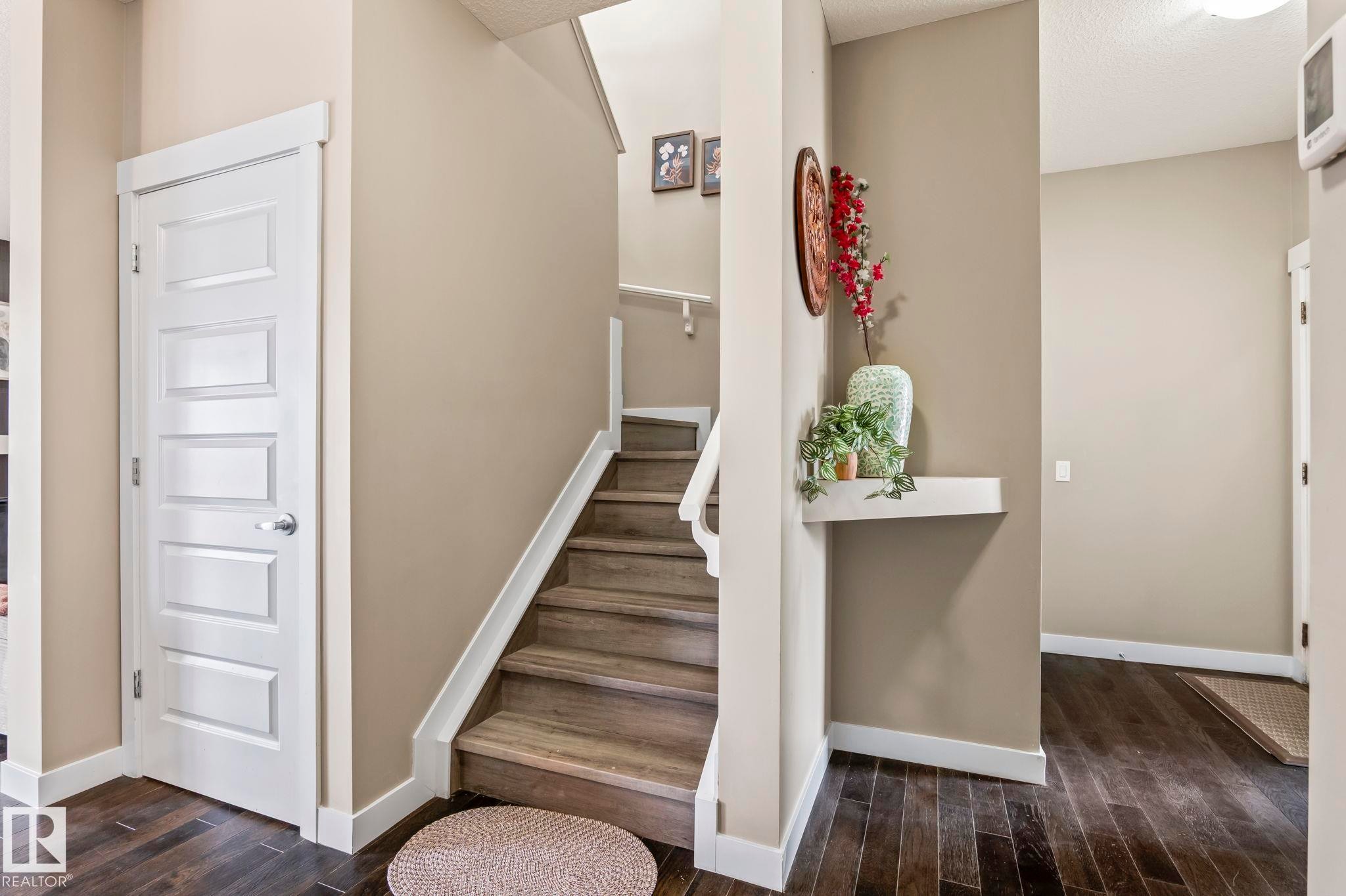 Staircase featuring wood-finish treads and white risers, framed by a matching white handrail - 8431 216 St Nw Nw, Edmonton, AB - Indoor Photo Showing Other Room