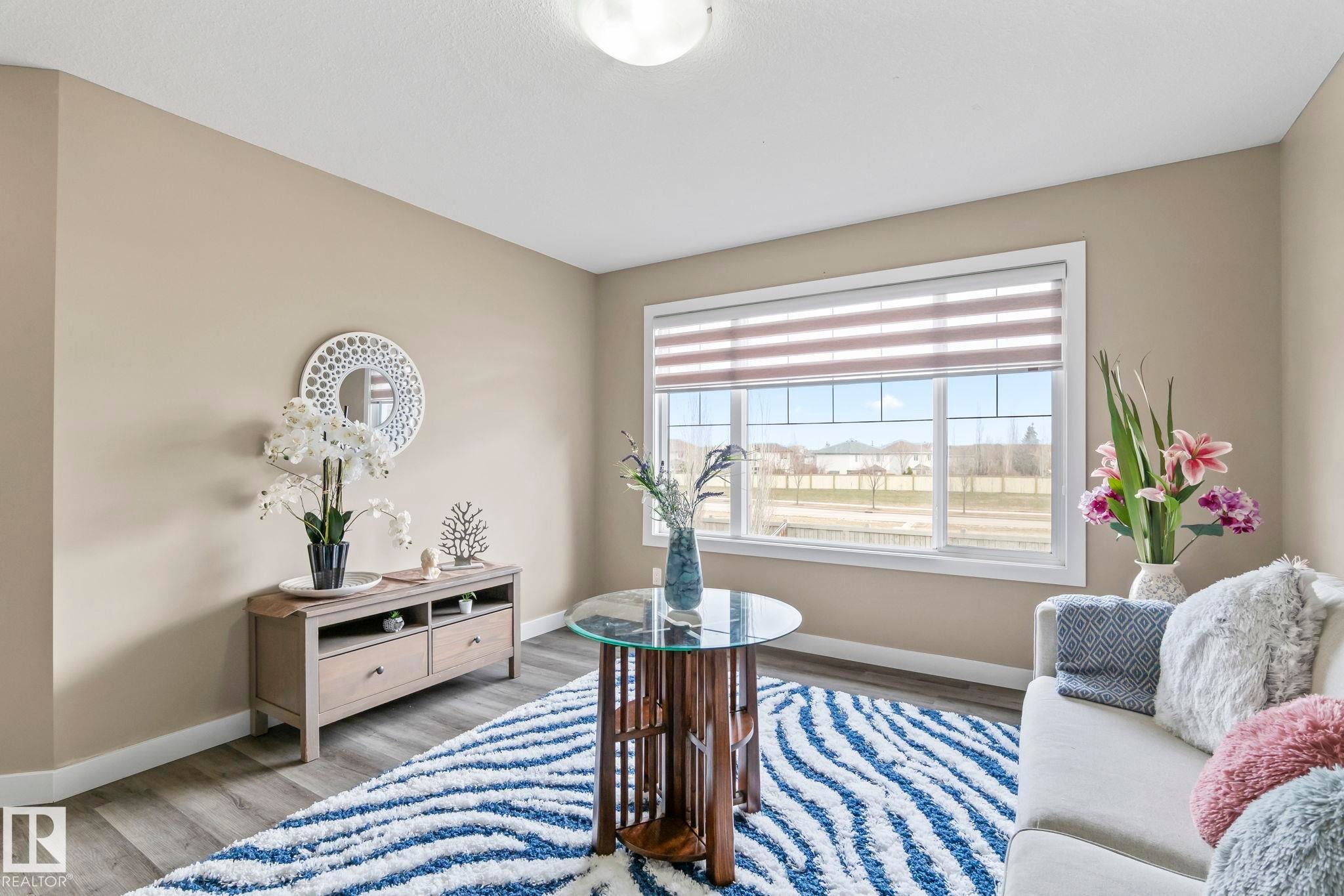 Bright interior space with wood-finish flooring and neutral wall tones - 8431 216 St Nw Nw, Edmonton, AB - Indoor