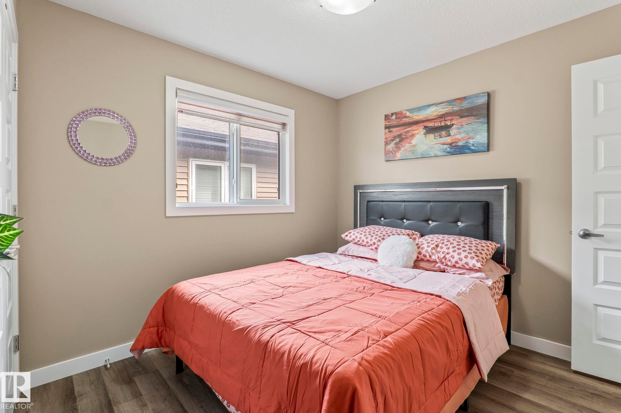 Bedroom featuring wood-finish flooring, a neutral wall color, and a white trim window - 8431 216 St Nw Nw, Edmonton, AB - Indoor Photo Showing Bedroom