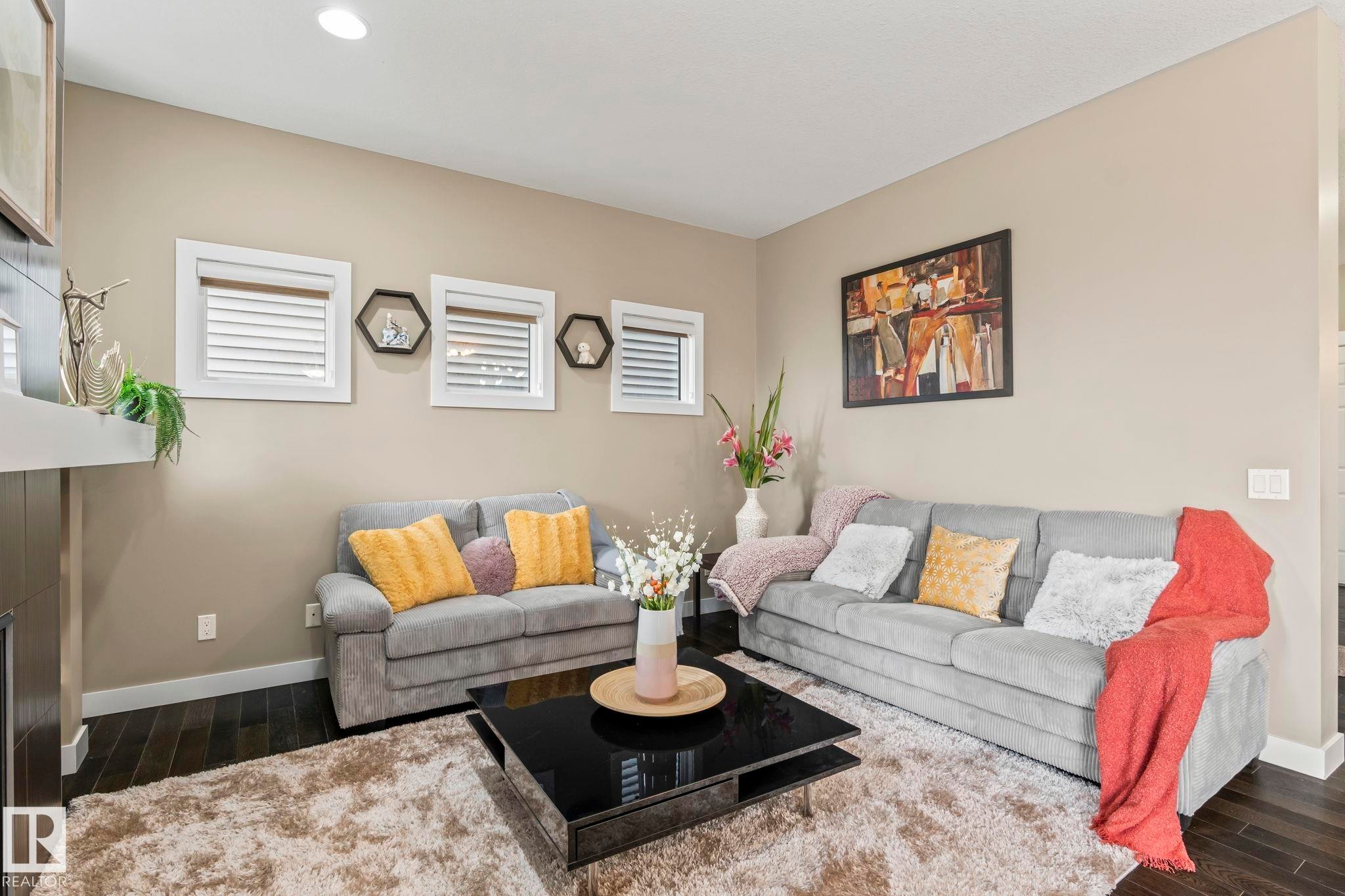 Spacious living area featuring dark wood-finish flooring, recessed lighting, and a neutral wall palette - 8431 216 St Nw Nw, Edmonton, AB - Indoor Photo Showing Living Room