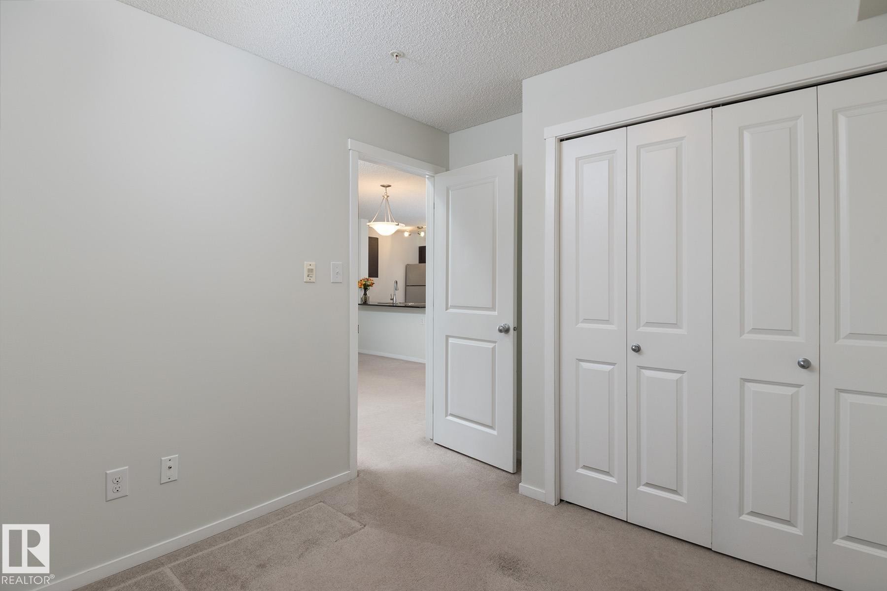 White bi-fold closet doors with brushed nickel hardware - 111 25 Element Dr, St. Albert, AB - Indoor Photo Showing Other Room