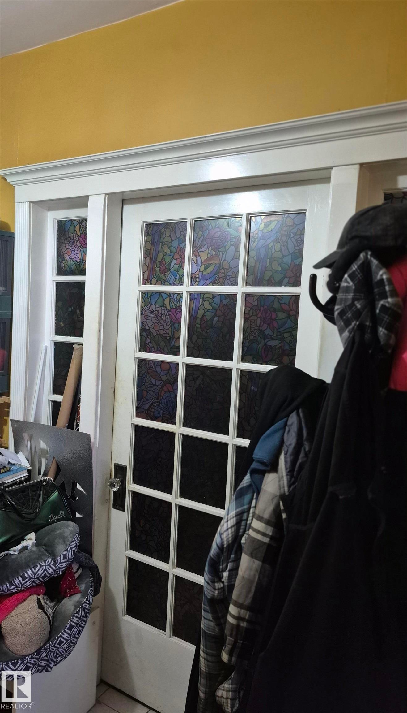 White interior door featuring multi-pane glass with decorative film, framed by an overhead transom and side panel with matching glass - 11301 87 Street, Edmonton, AB - Indoor Photo Showing Other Room