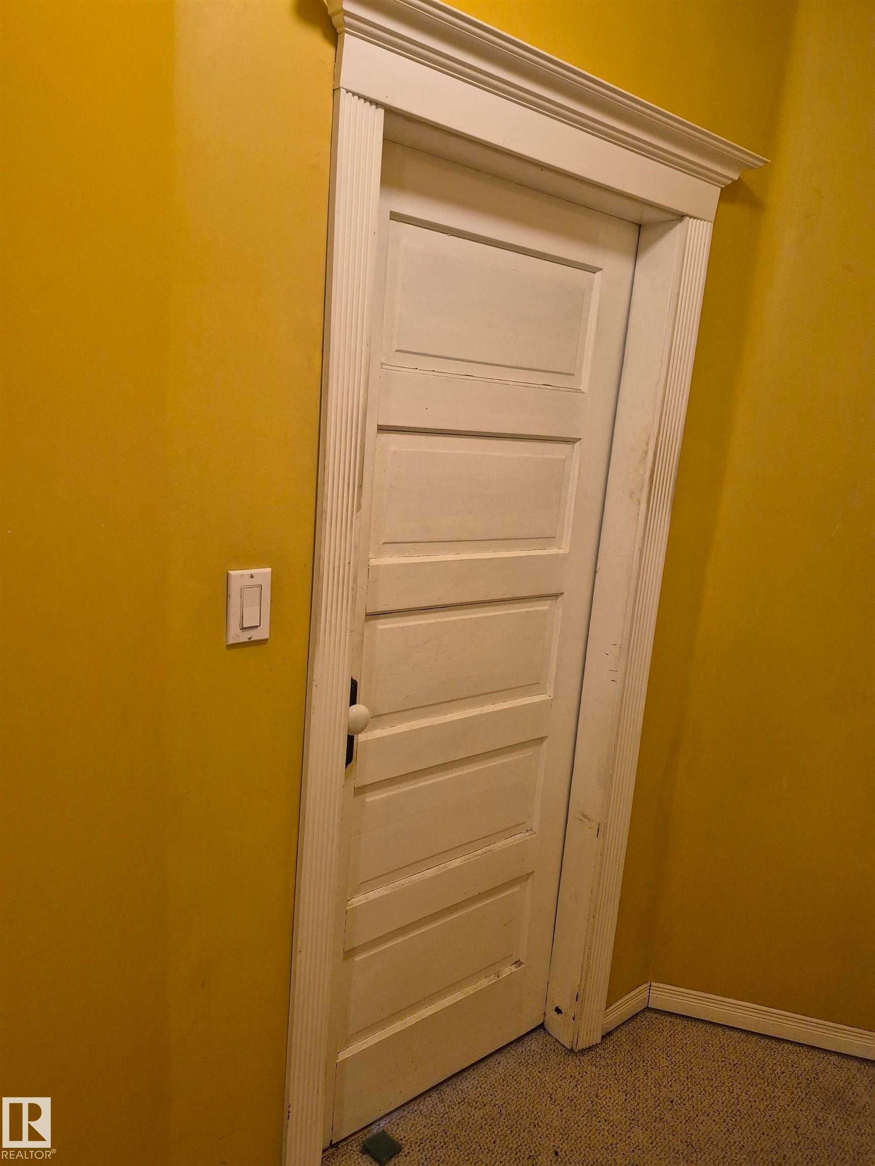 Paneled interior door with ornate trim - 11301 87 Street, Edmonton, AB - Indoor Photo Showing Other Room