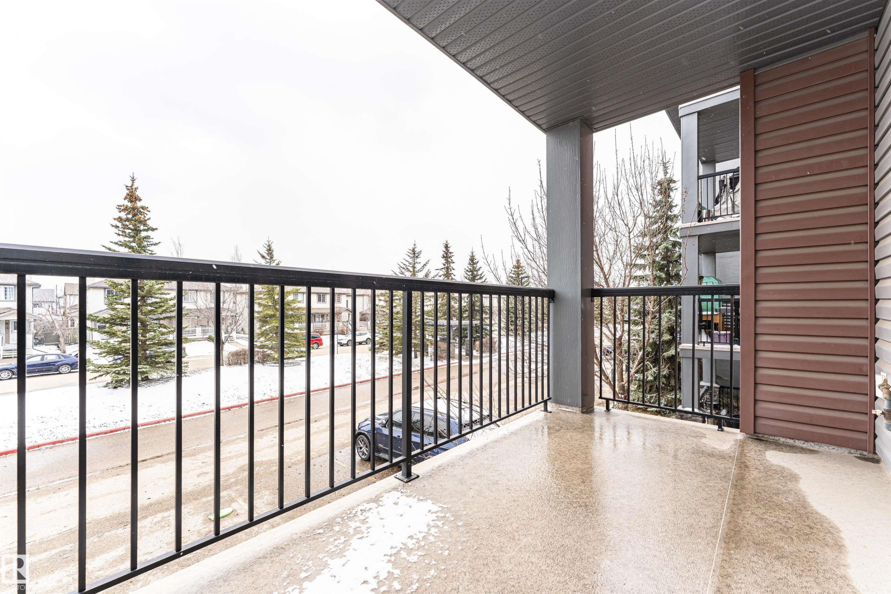 Outdoor balcony featuring a textured concrete floor, black metal railing, and a gray soffit - 219 646 Mcallister Loop, Edmonton, AB - Outdoor With Balcony With Exterior