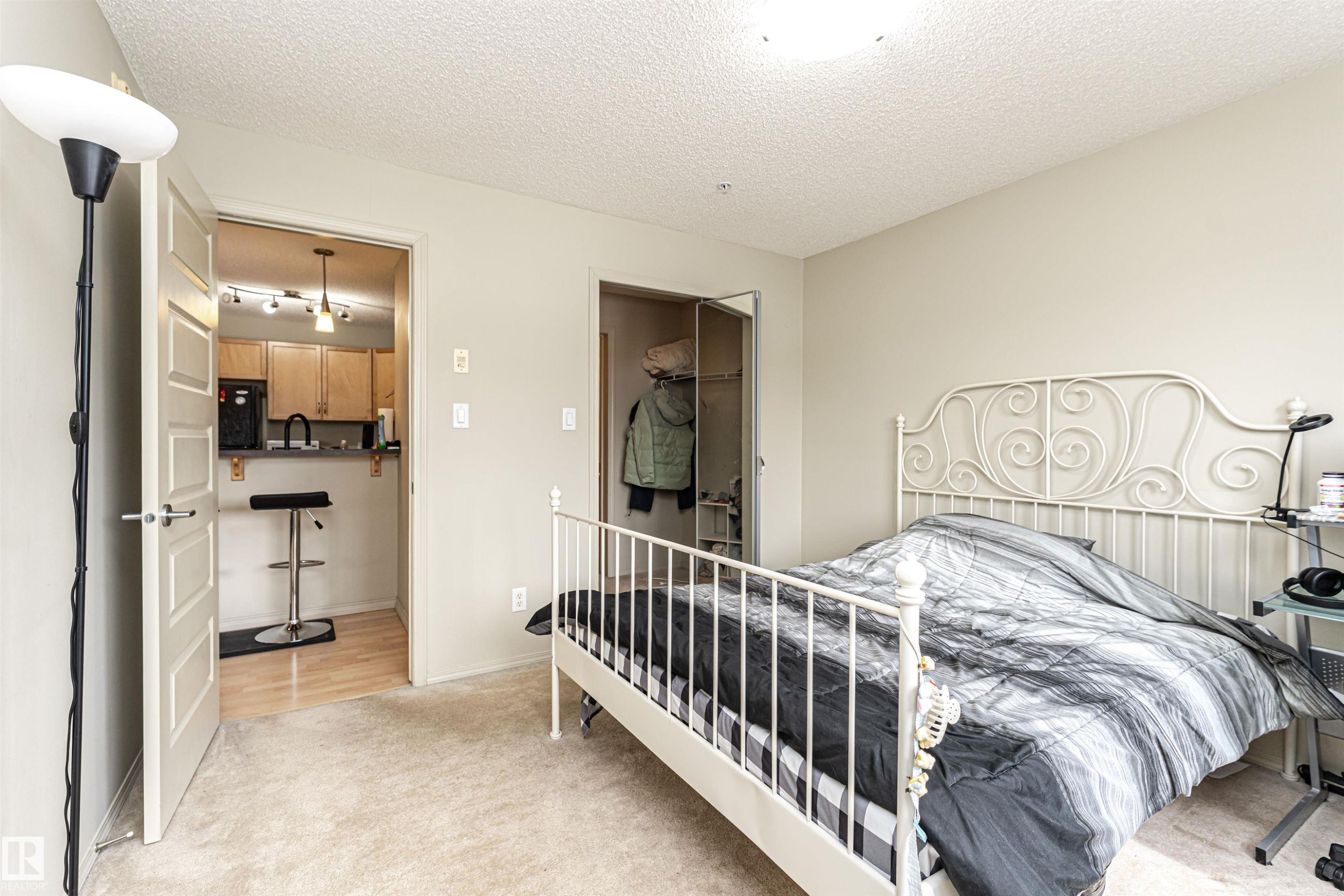 Bedroom featuring carpeting, light neutral wall color, and a ceiling-mounted light fixture - 219 646 Mcallister Loop, Edmonton, AB - Indoor Photo Showing Bedroom