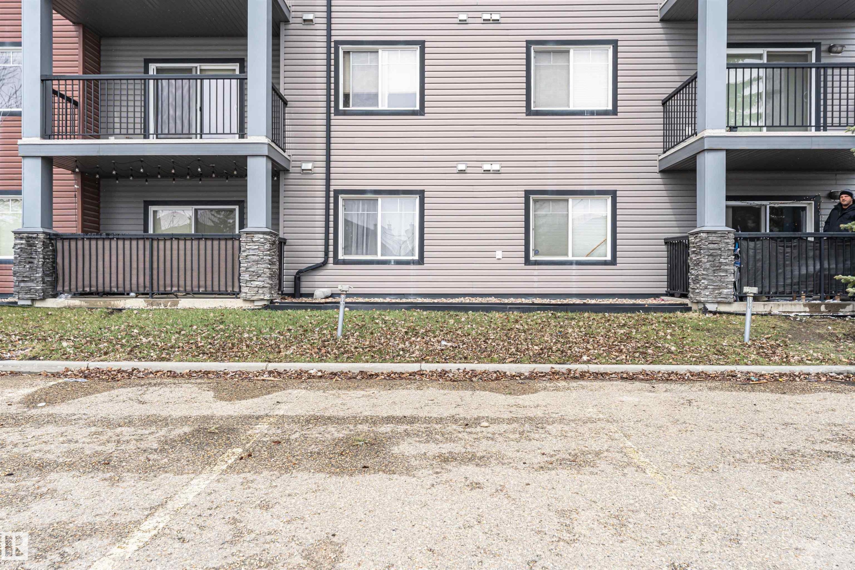 Multi-story building exterior featuring horizontal siding and dark-trimmed windows - 219 646 Mcallister Loop, Edmonton, AB - Outdoor With Balcony