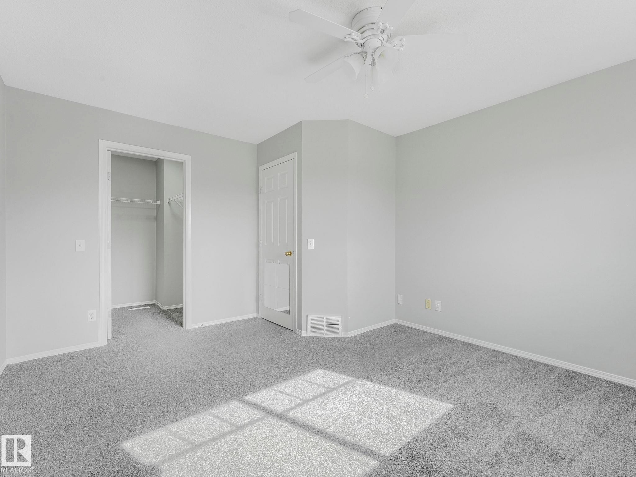 This room features light grey walls and grey carpet flooring, offering a neutral palette - 175 150 Edwards Drive, Edmonton, AB - Indoor Photo Showing Other Room