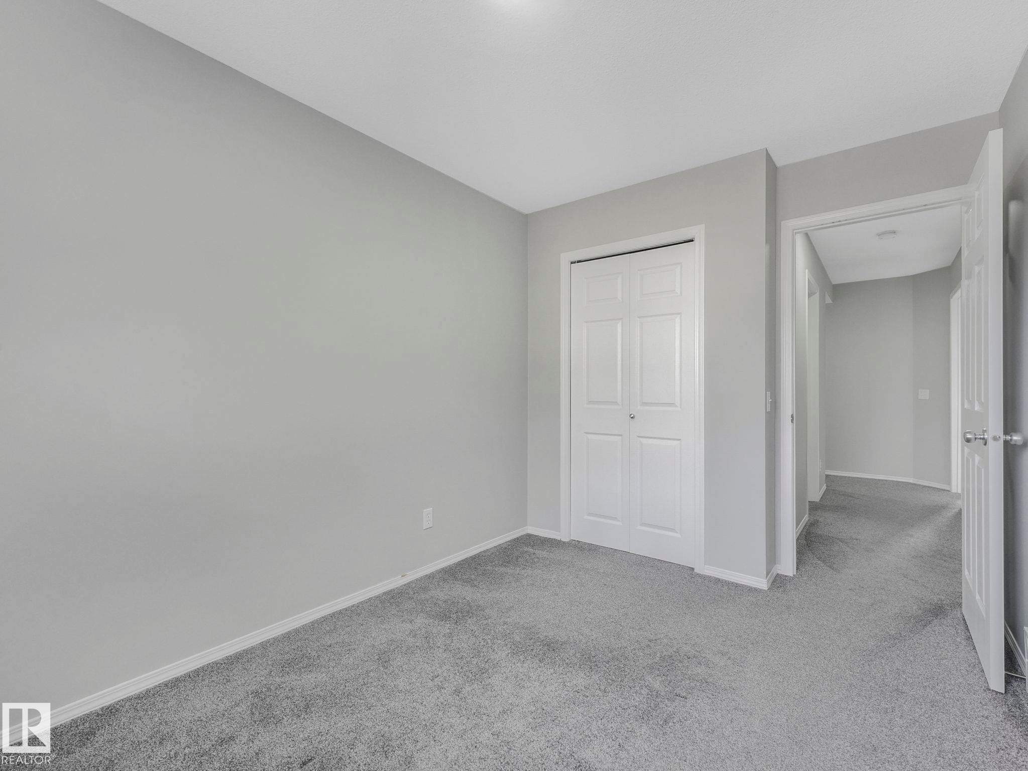 This space features a neutral color palette with light grey walls and light grey carpet - 175 150 Edwards Drive, Edmonton, AB - Indoor Photo Showing Other Room