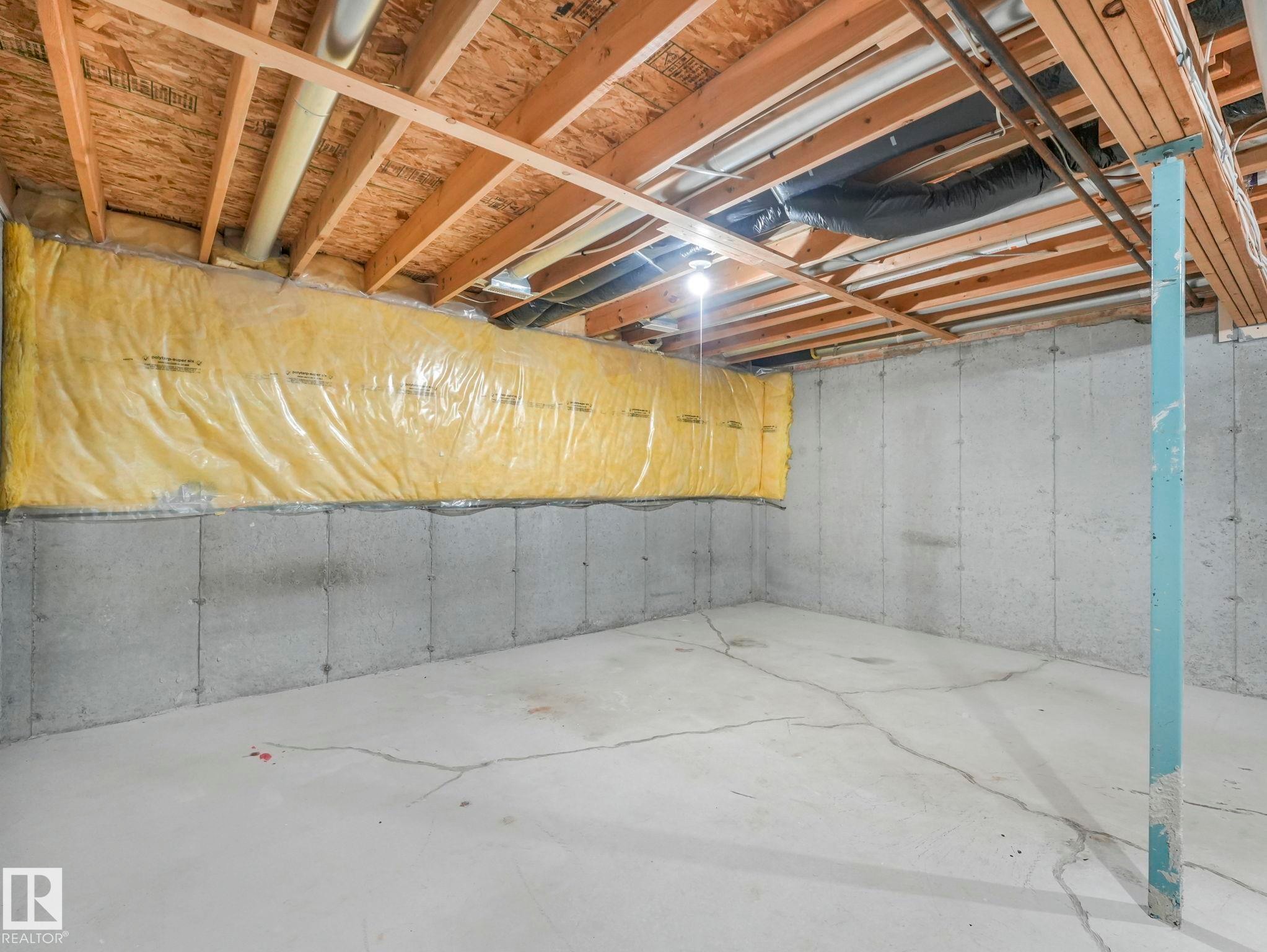 The property features an unfinished basement with concrete walls and flooring, exposed wooden ceiling joists, and visible insulation along a wall - 175 150 Edwards Drive, Edmonton, AB - Indoor Photo Showing Basement