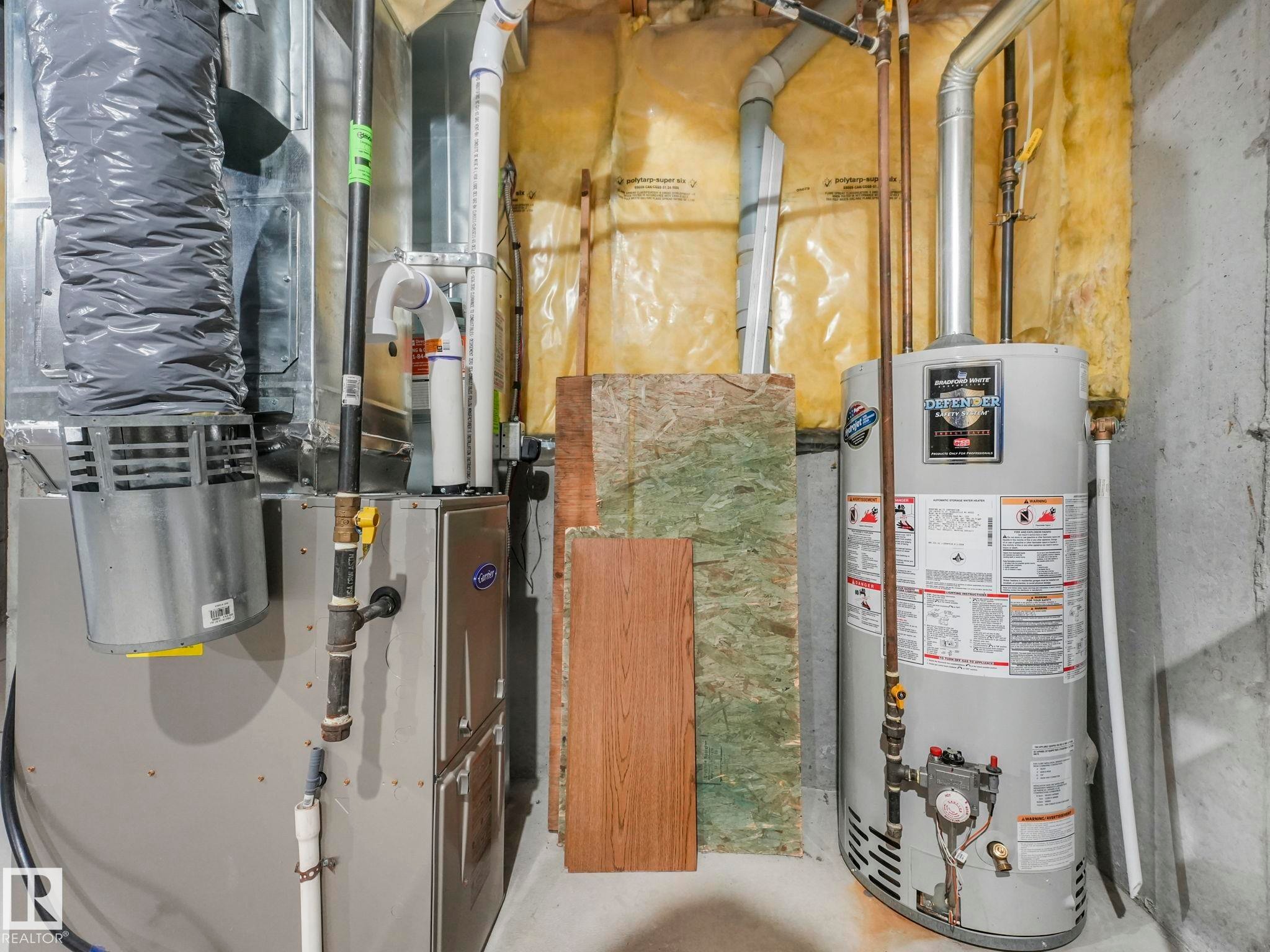 The property features a water heater and a furnace, with exposed ductwork and piping - 175 150 Edwards Drive, Edmonton, AB - Indoor Photo Showing Basement