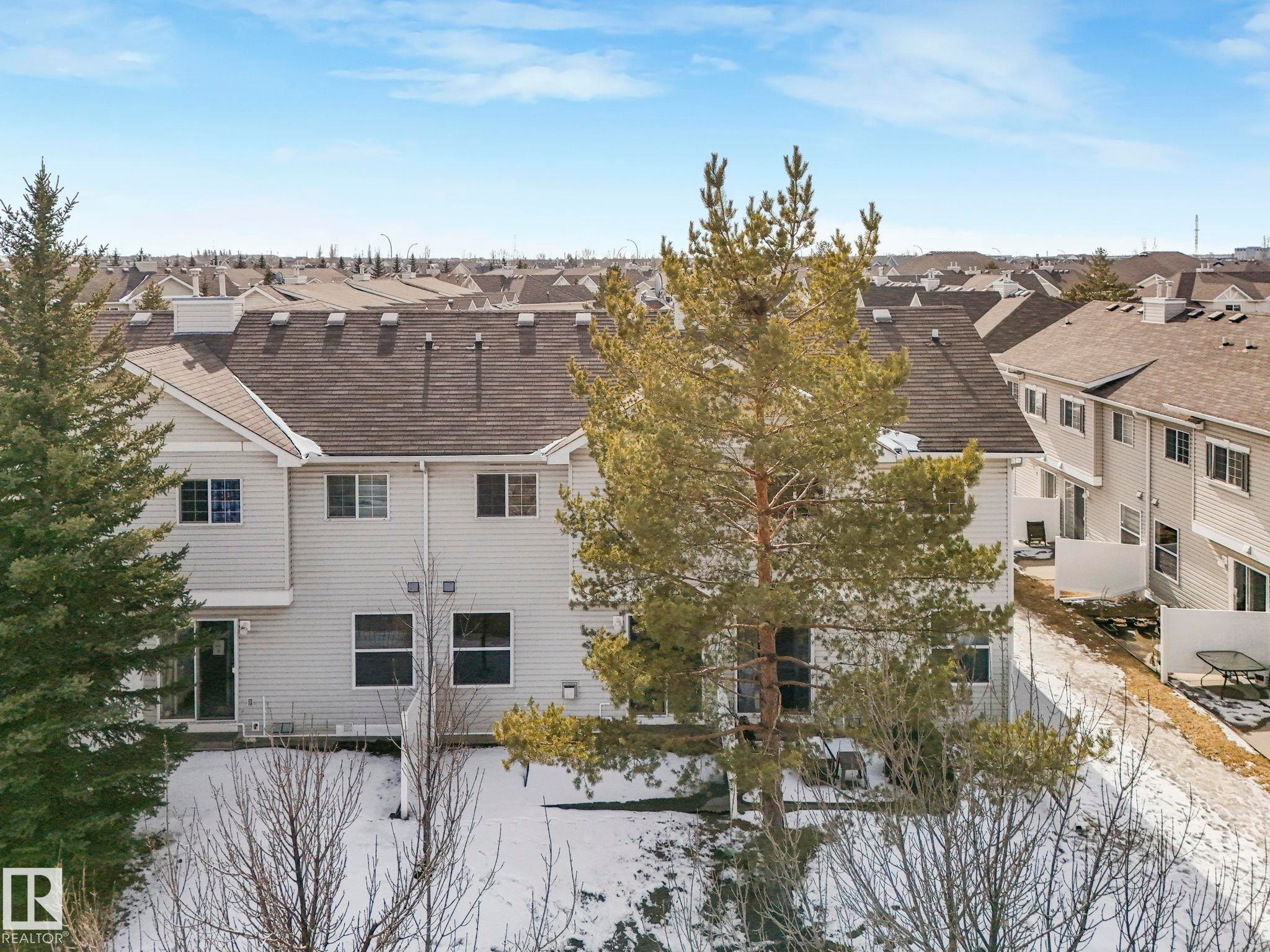 The property features a multi-story exterior with light-colored siding and a dark roof - 175 150 Edwards Drive, Edmonton, AB - Outdoor