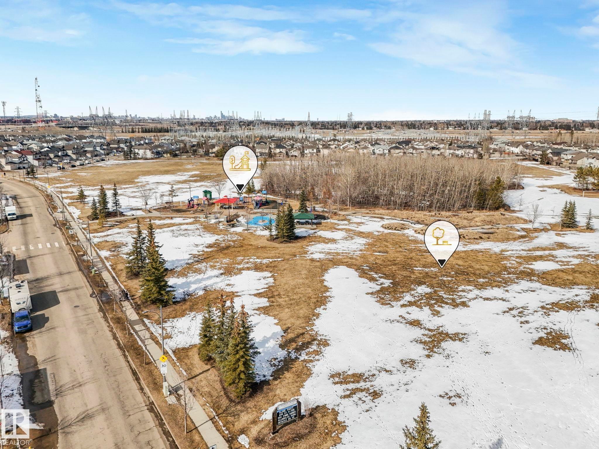 Expansive outdoor area featuring a playground, green spaces, and surrounding residential properties - 175 150 Edwards Drive, Edmonton, AB - Outdoor With View